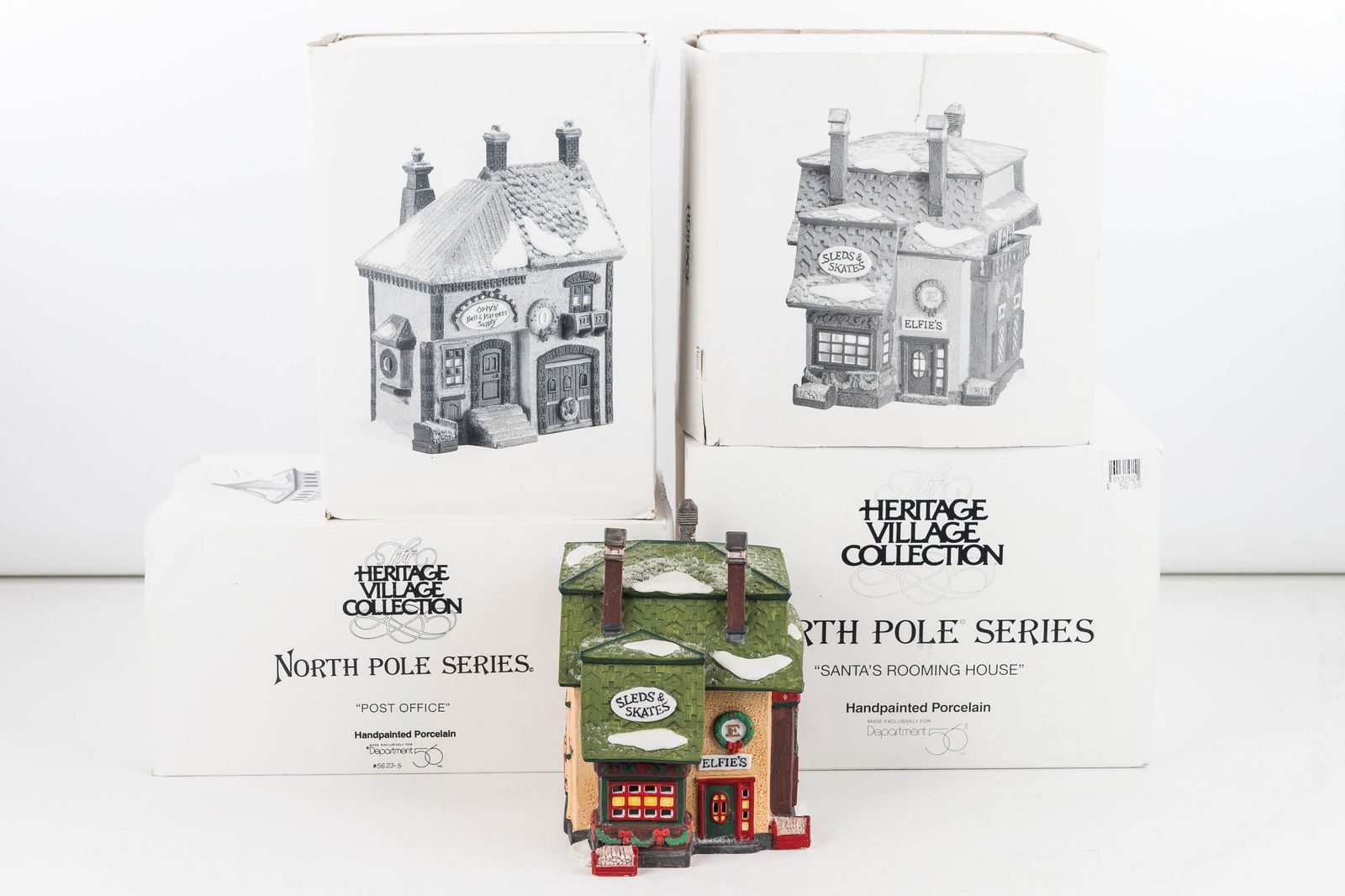 Department 56 Collection/North Pole Series: Including Orly's bell and harness Shop, Post Office and two others. Four total items in original boxes