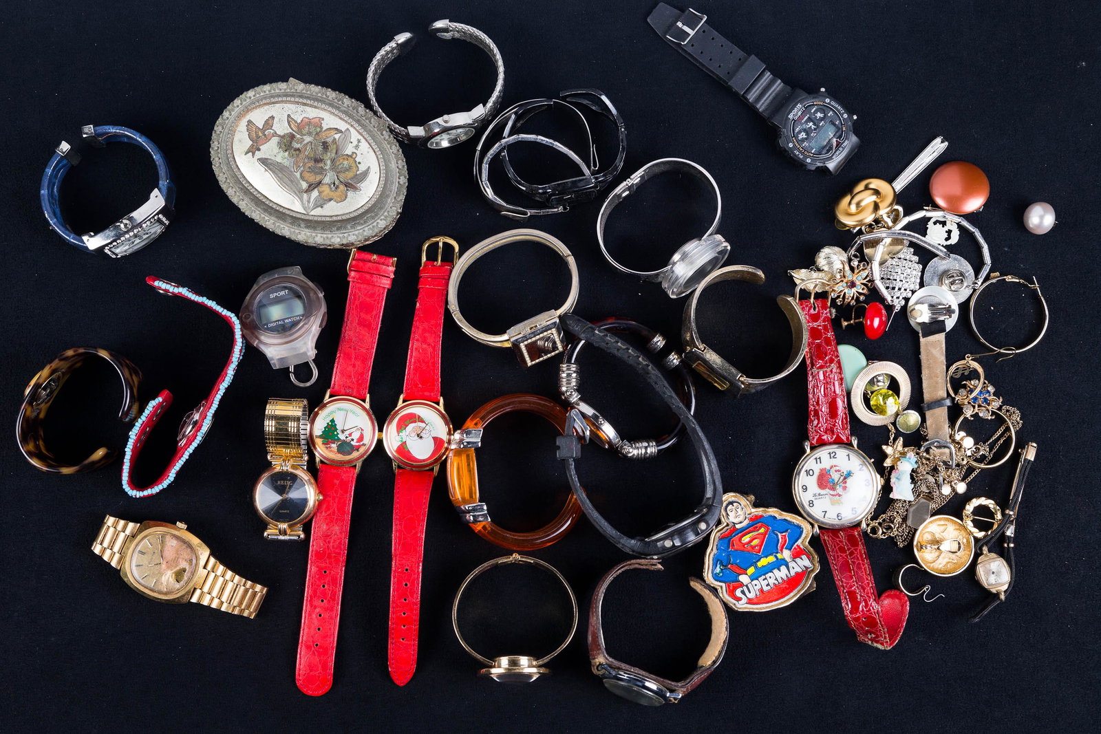 Cuff Watches, Watch Parts, and Single Earrings: Lot includes Novell with gold tone cuff band, Jan Leslie with faux tortoise shell band, Zanadu, Christmas watches, Focus with locket, Nelson 17 Jewel with round gold tone face, other watches, watch pa