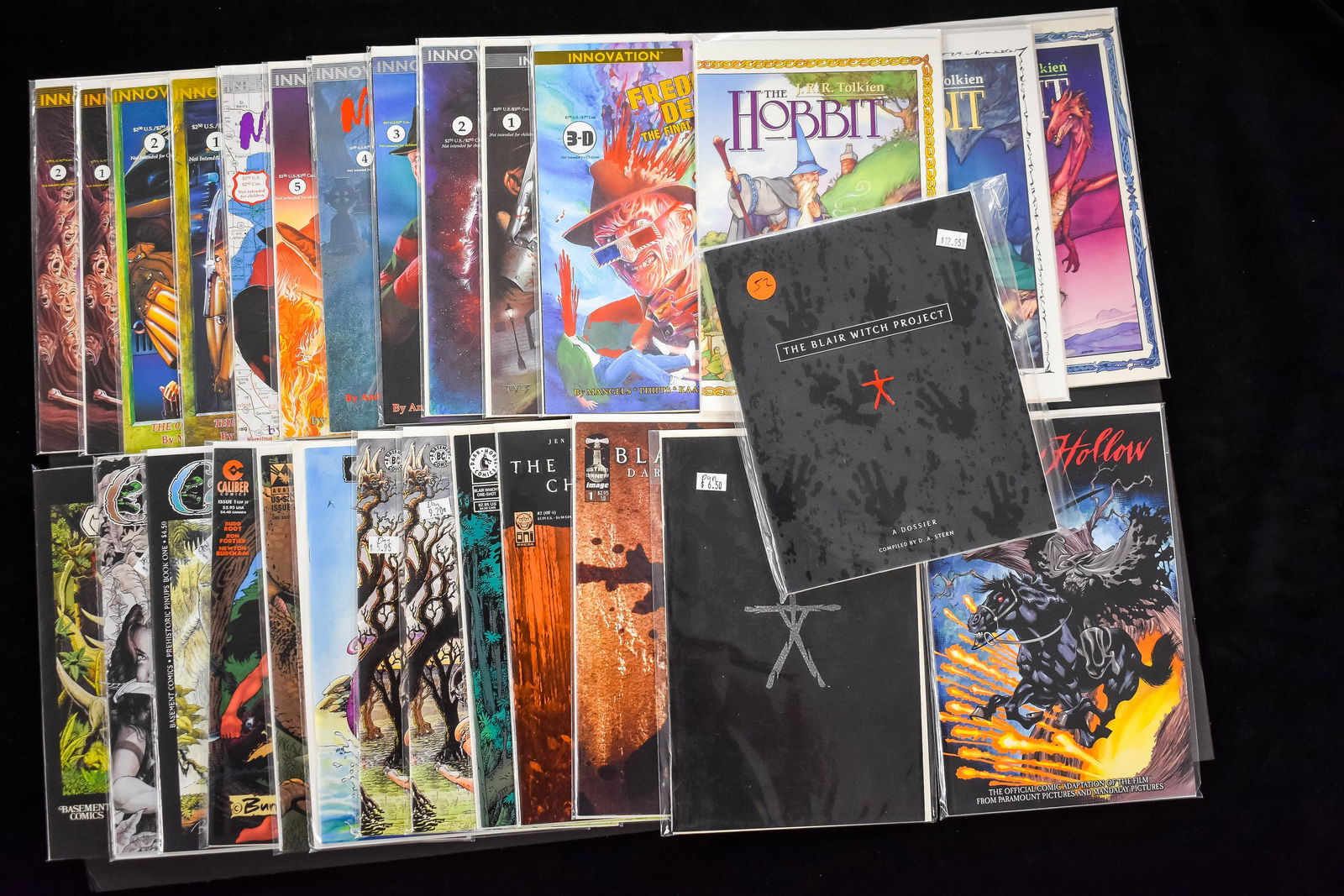 Mix of Horror Comic Books (28 total): 11 Freddie Krueger Nightmare on Elm Street, 3 comics of The Hobbit, 5 Blair Witch Project comics including a Dossier and a glow in the dark cover comic, 8 Cave Woman comics and a Sleepy Hollow