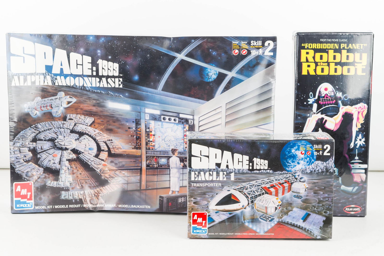 Space / SciFi Model Kits (3): AMT Ertl Space: 1999 Eagle 1 Transporter c1998 model 30066 and Alpha Moon Base c1998 model 30067-10D (box lib some warping), Polar Lights Robby the Robot c1999 model 5025. All sealed, new in box.