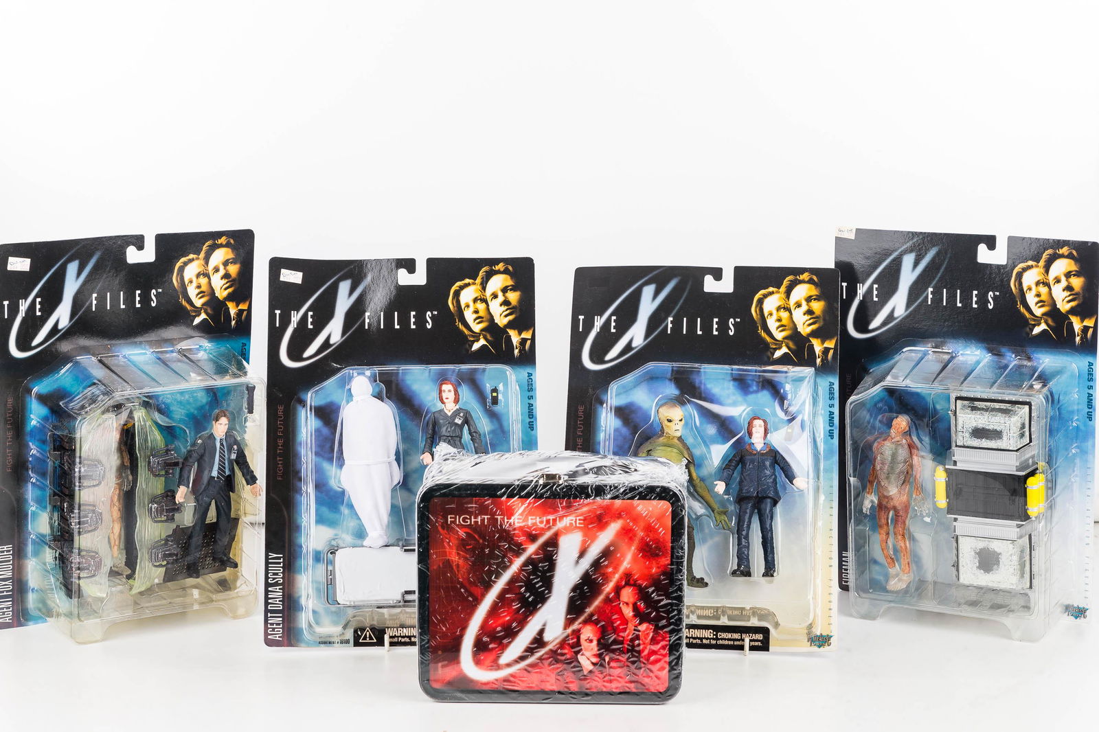 The X Files Figures (4) and Lunch Box: Lunchbox by G Whiz "Fight the Future" in original packaging and Ultra Action Figures Series 1 with two Agent Dana Scully, 1 Fox Mulder, and Fireman, in original packaging.