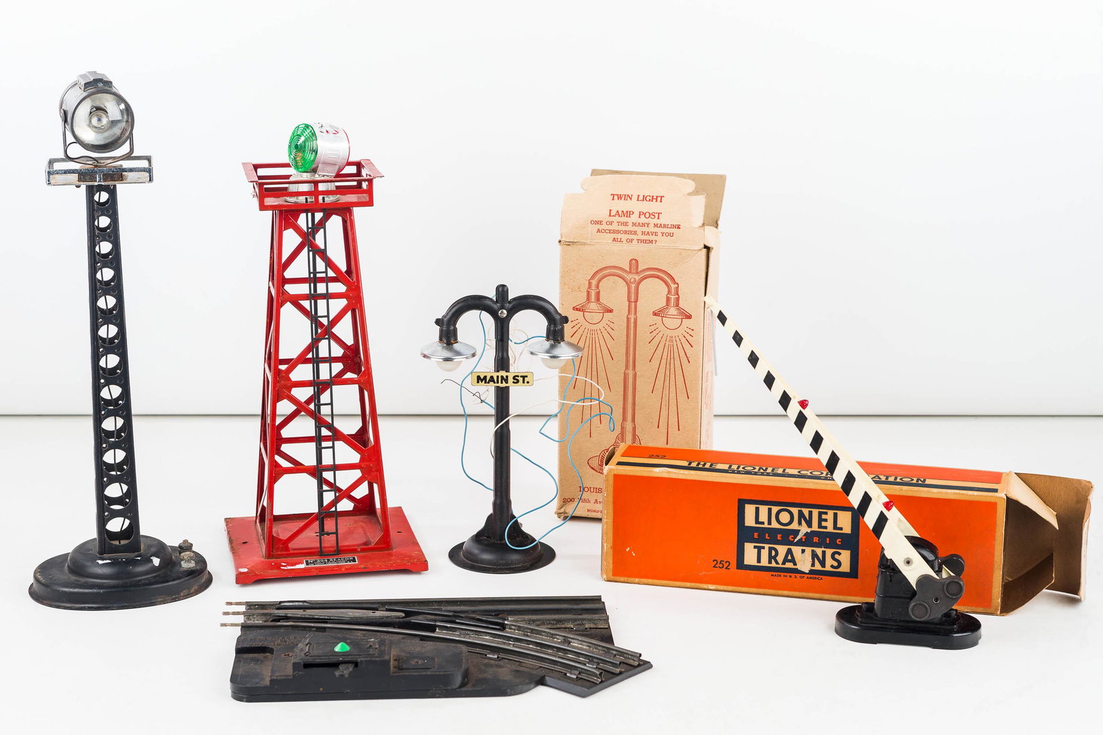 Lionel and Marx Metal Beacons and Related: Including Lionel Beacon #394, Lionel Automatic crossing gate #252 with box, Marx twin lamp post with box, an unmarked black beacon and a Marx cross over.