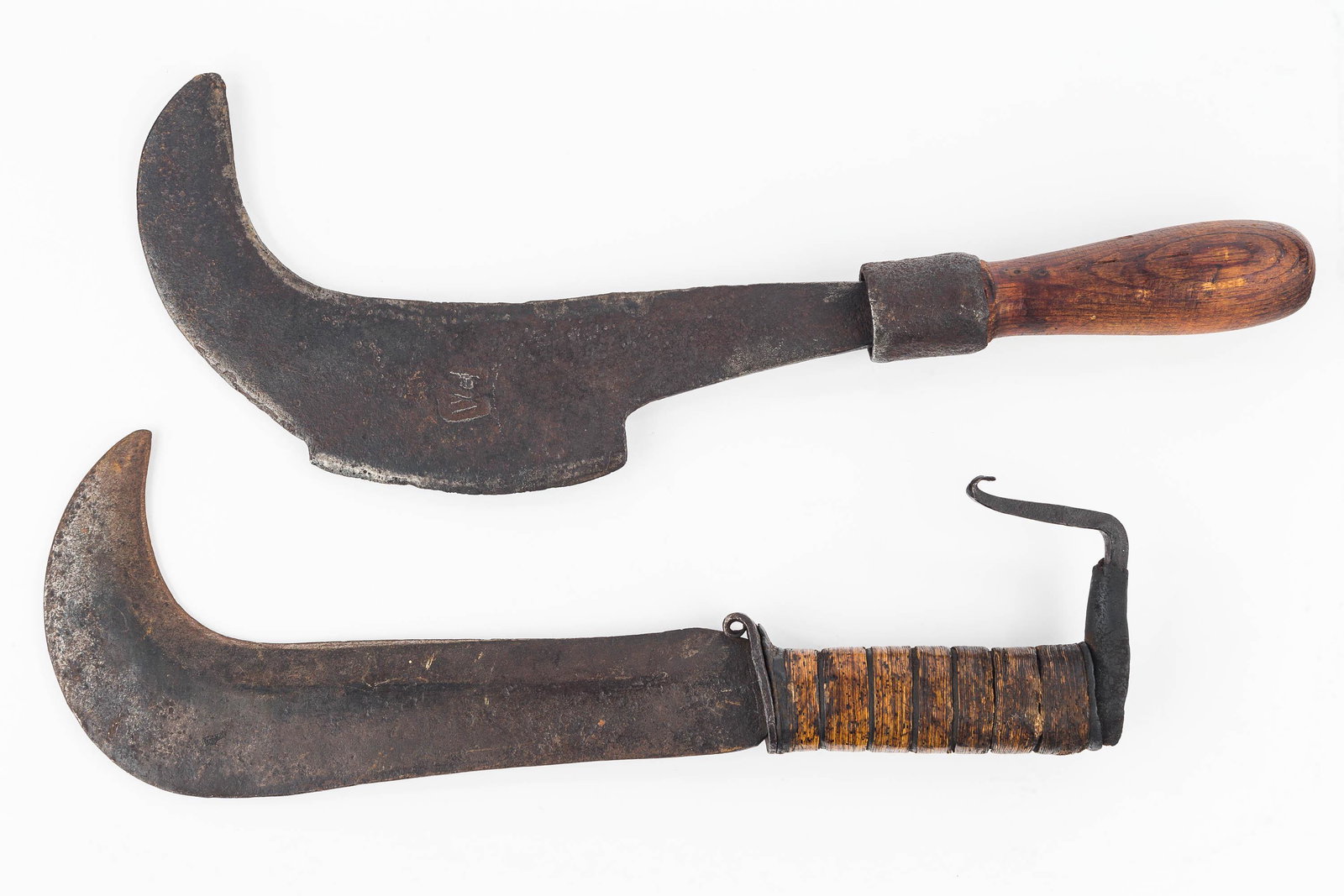 Two Early Artillery Type Billhooks: Larger Billhook measures 16" in length, made of hand wrought steel, has an obscure stamping on blade, it has unusual form with an extended blade section on back of blade as well as blade under curvatu