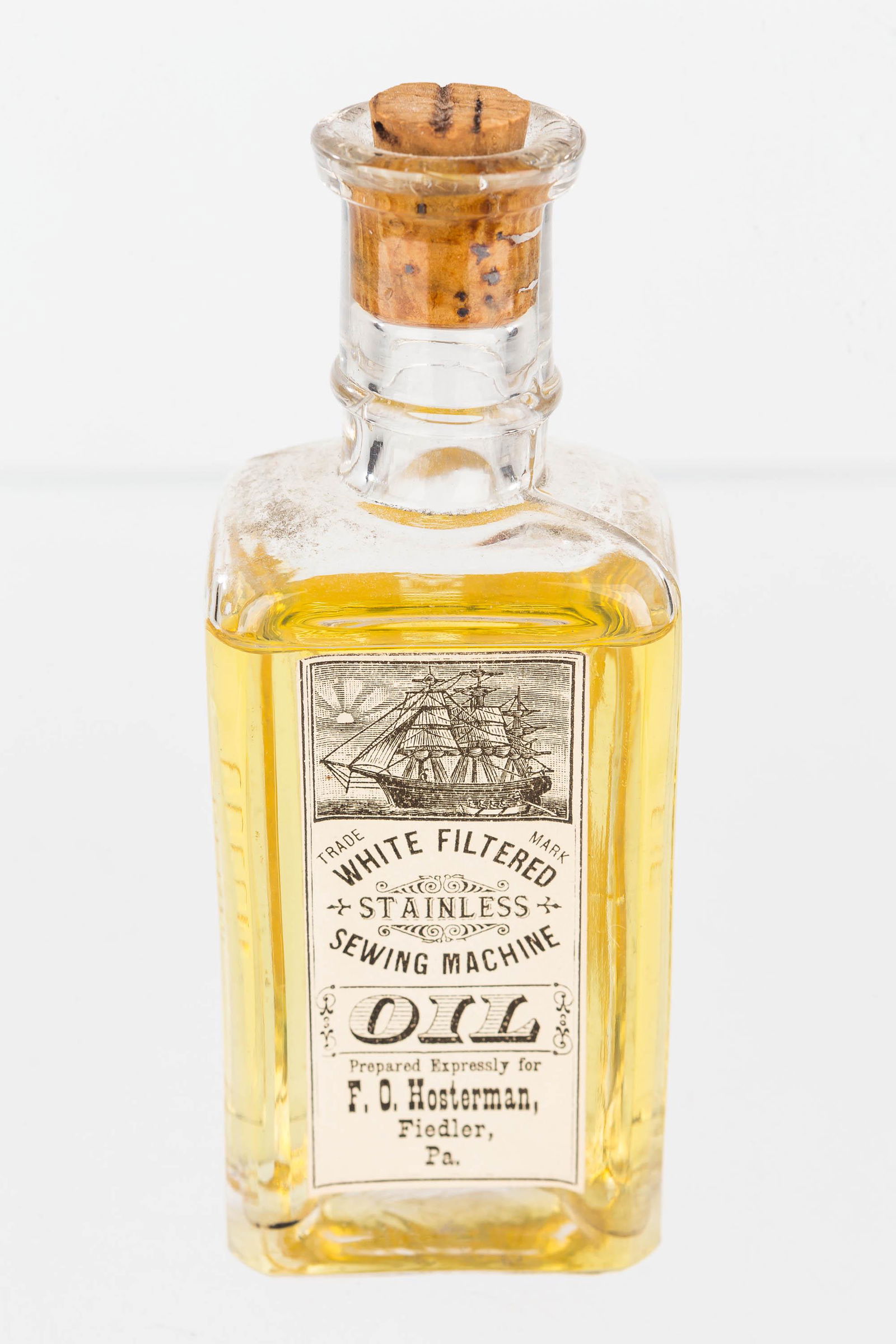 Vintage Sperm Whale Sewing Oil: Bottle measure approx. 4 3/4" high, it has original paper label, and the words "Sperm Sewing Machine Oil" molded into glass on back.