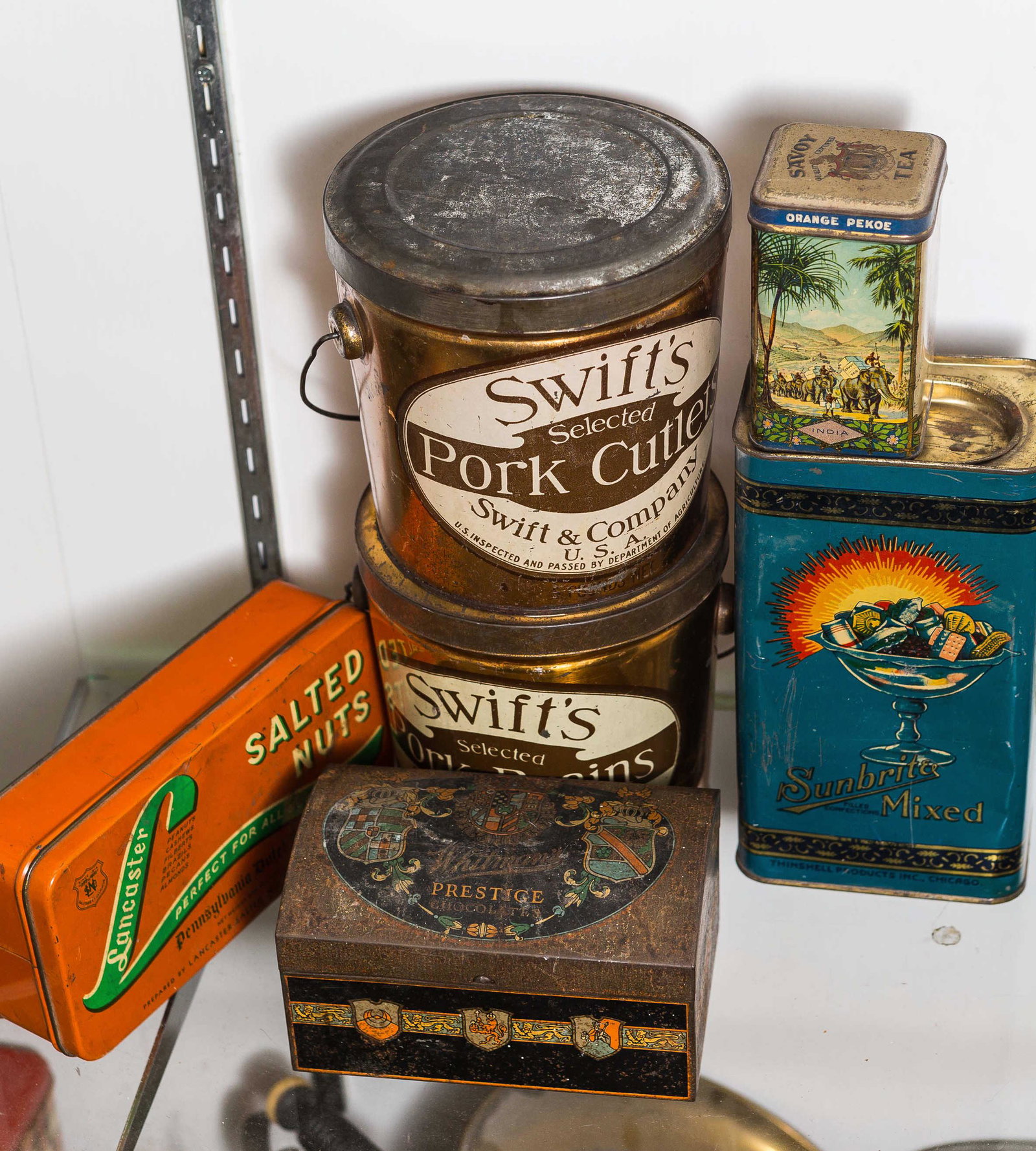 Vintage Advertising Tins: Including Swiss pork cutlets, Swiss pork brains, a Savoy tea tin, a Sunbright mixed candy tin, and an early Whitman's chocolate tin.