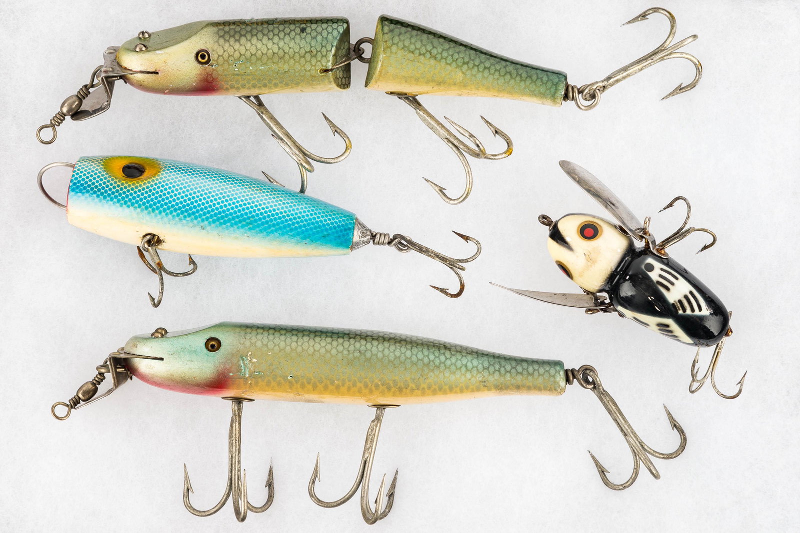 Deepwater Fishing Lures: Including a Heddon Crazy Crawler, a jointed wooden fish with glass eyes, an Arbogast's Scudde with glass eyes, and a large unjointed wooden fish with glass eyes.