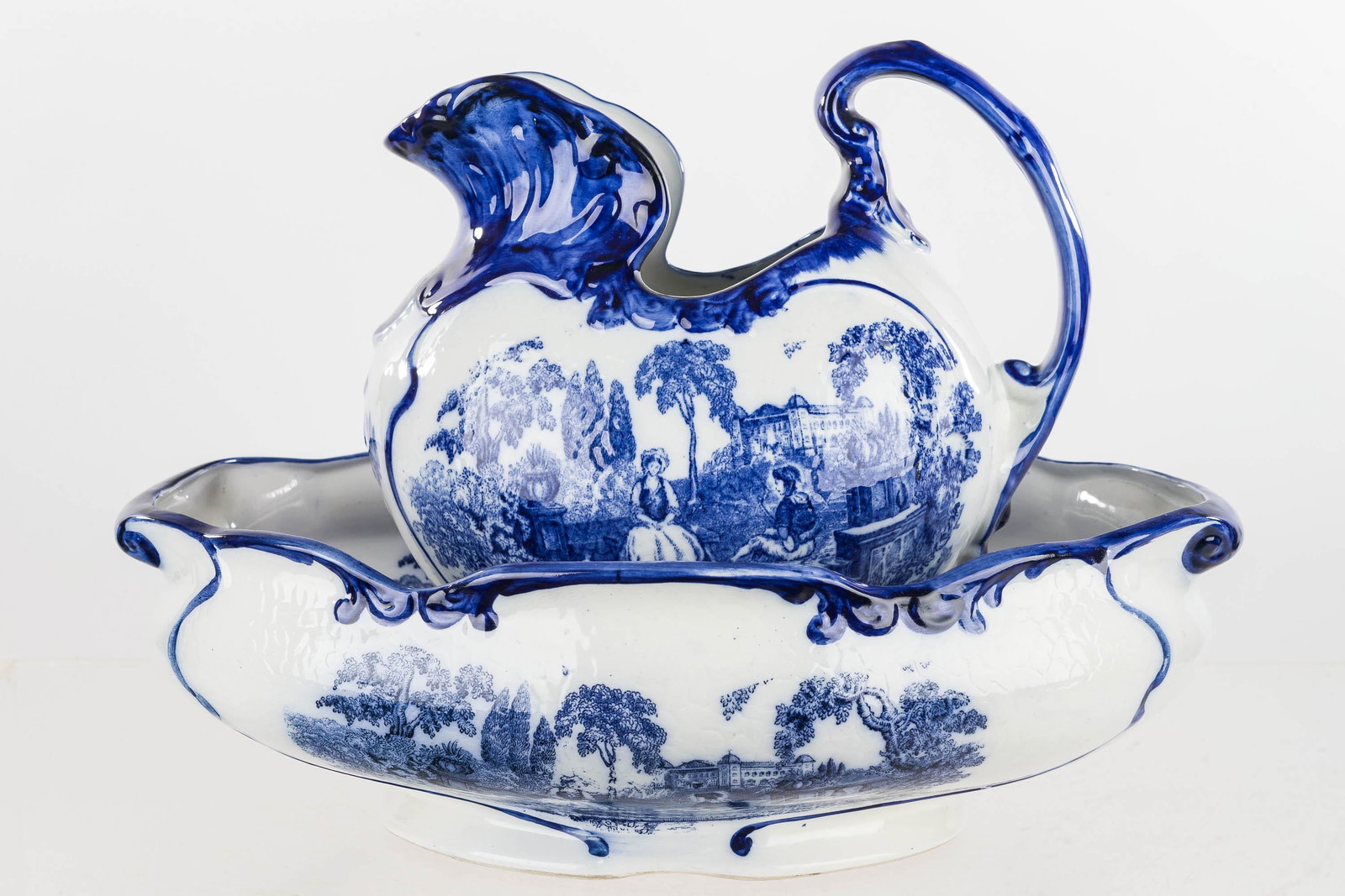 Staffordshire Flow Blue Pitcher & Bowl "Romantic": This is a Staffordshire "Romantic" pattern pitcher and bowl. The pitcher measures approx. 11" H; the bowl measures 17" x 12.5" and is marked "Romantic Flow Blue T.M. Staffordshire, England"