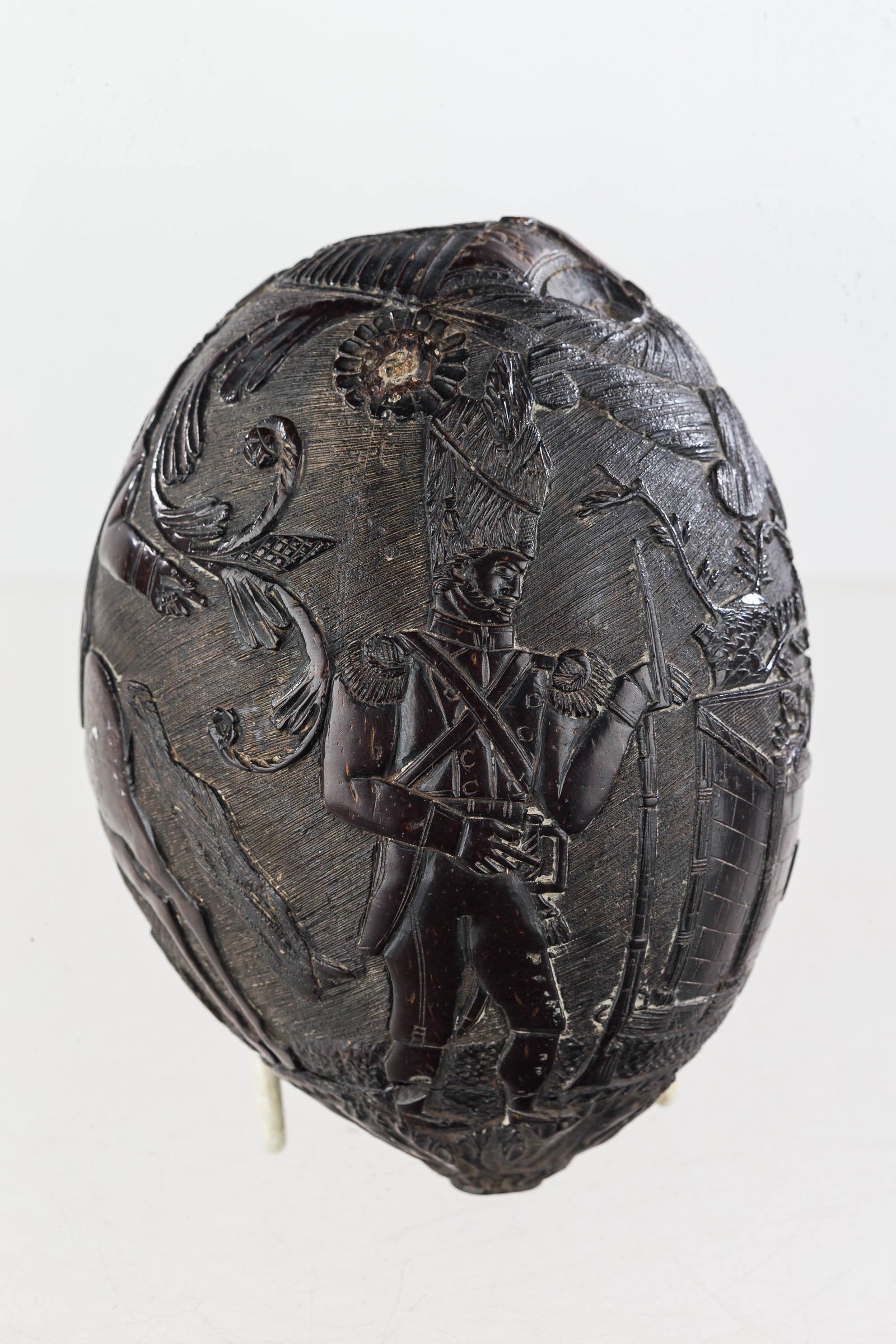 Napoleonic Carved Bugbear Coconut Powder Horn: This bugbear is ornately carved with Napoleon on horseback, a soldier with musket, wall with the letter "N", and leaf and floral decoration. It is ported at top and bottom, free of cracks, and measure
