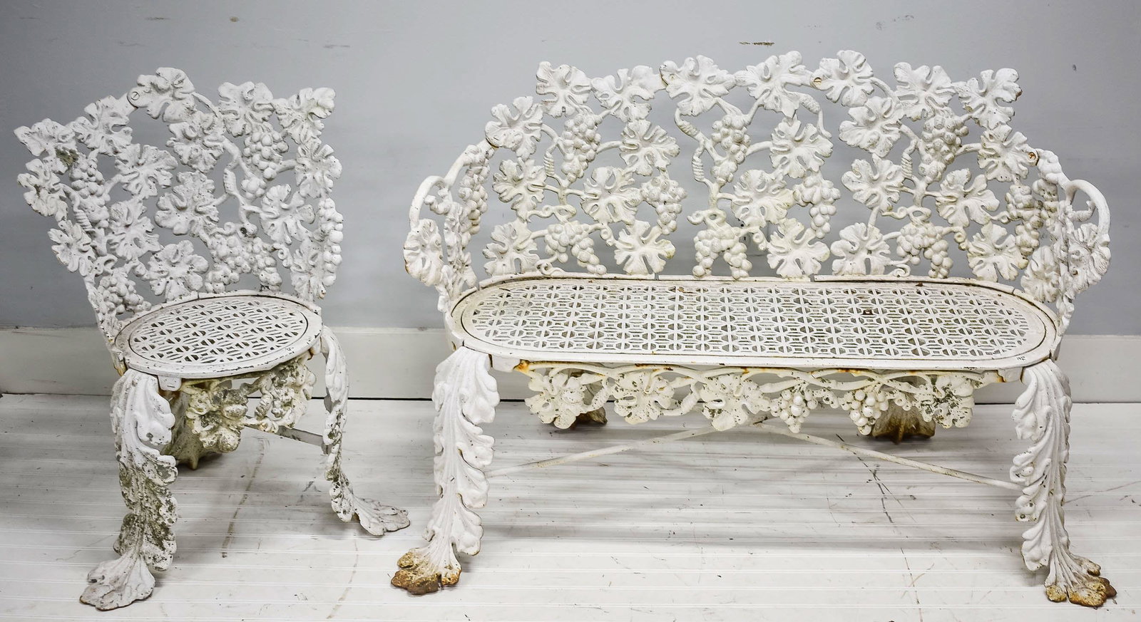 Cast Iron Garden Seating circa 1920: This heavy cast iron love seat has a matching chair in a grape and leaf pattern. The pair have been exposed to the elements, and there is some oxidation.