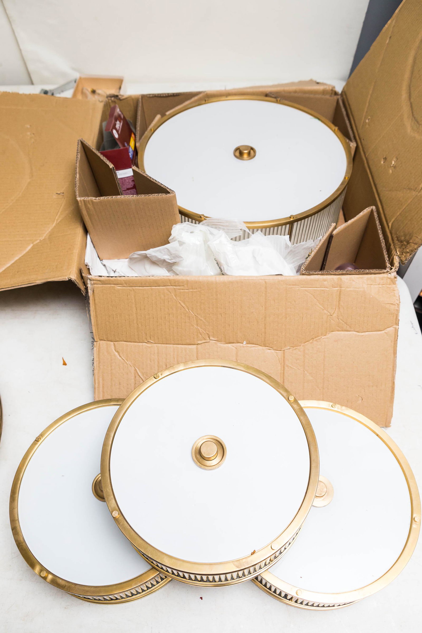 Art Deco Style Lighting Fixtures and Sconces: This collection includes an art deco style lamp with a brass frame with glass tubes and a white glass base measuring approximately 7" high and 18" in diameter. Lot also includes (3) matching 12" ceili