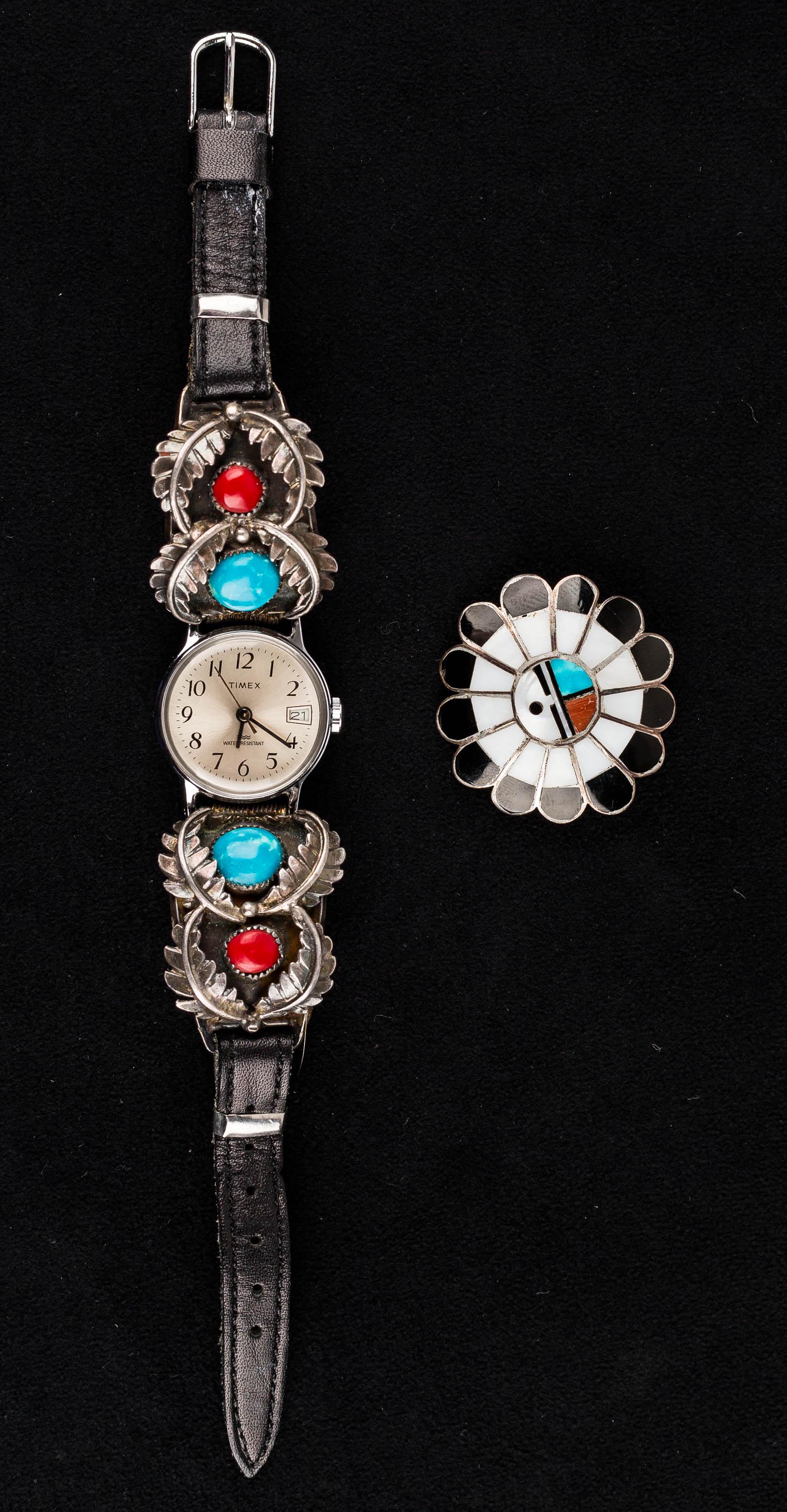 Native Sterling Watch w/ Band & Pendant Pin: Lot includes a well-detailed, sterling silver turquoise and coral leather watch strap, signed "Annie Eagle", holding a Timex watch with date. Lot also includes sterling Zuni style pin/pendant inlaid w