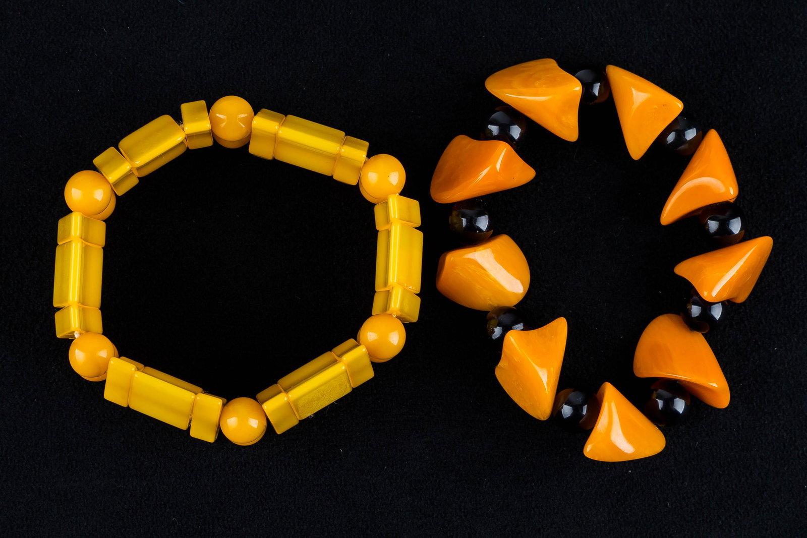 Abstract Bakelite (tested) Bracelets (2): Lot includes a vintage Bakelite (tested) bracelet with abstract butterscotch triangular sections separated by black beads and a yellow Bakelite (tested) bracelet with rectangular sections and yellow B
