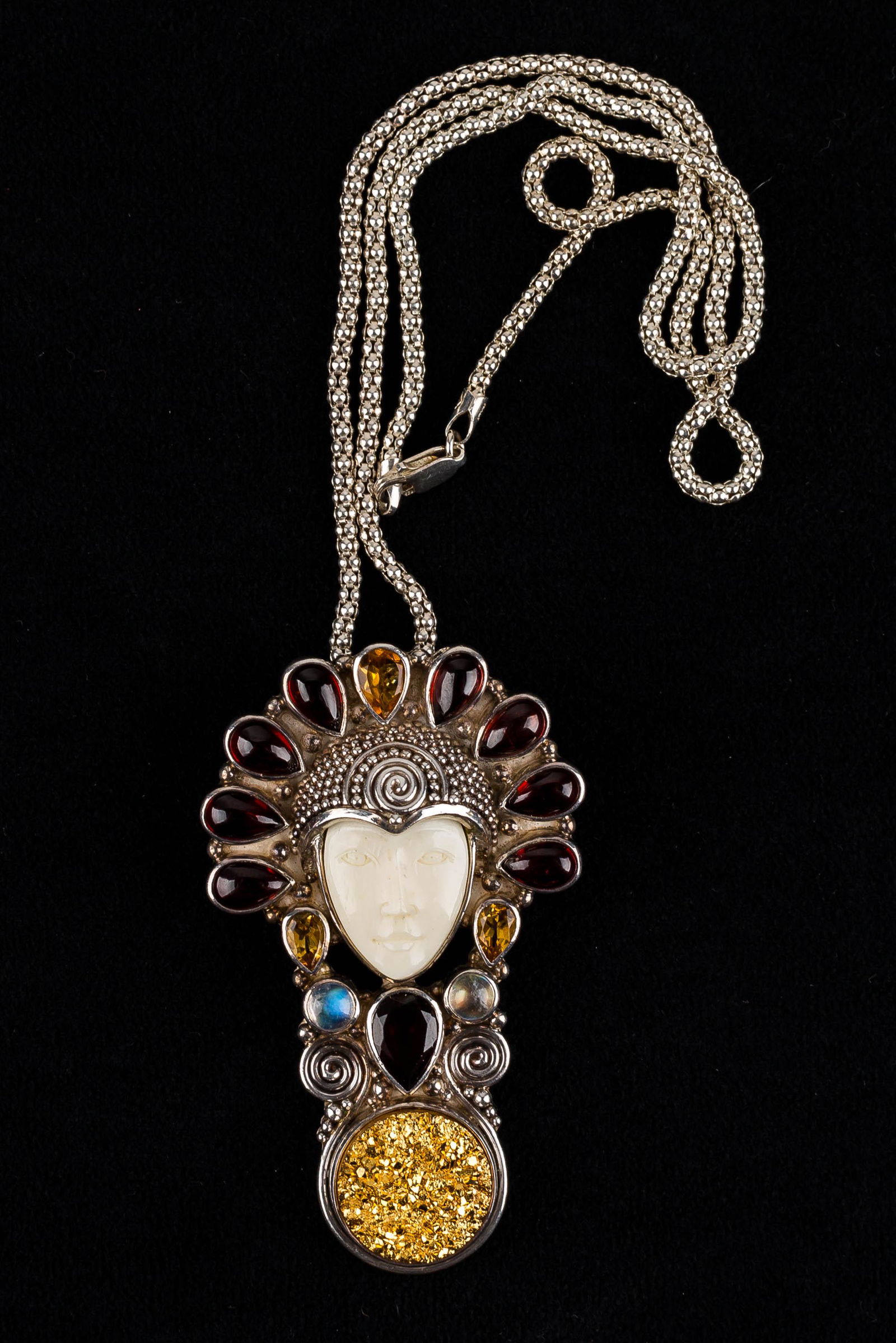 Sterling Sajen Jeweled Female Bust Necklace: This fine, sterling silver necklace features a face with moonstone, garnet, and citrine headdress and a large, bottom finial gold kunzite pendant. The pendant is marked Sajen .925 and measures approx.