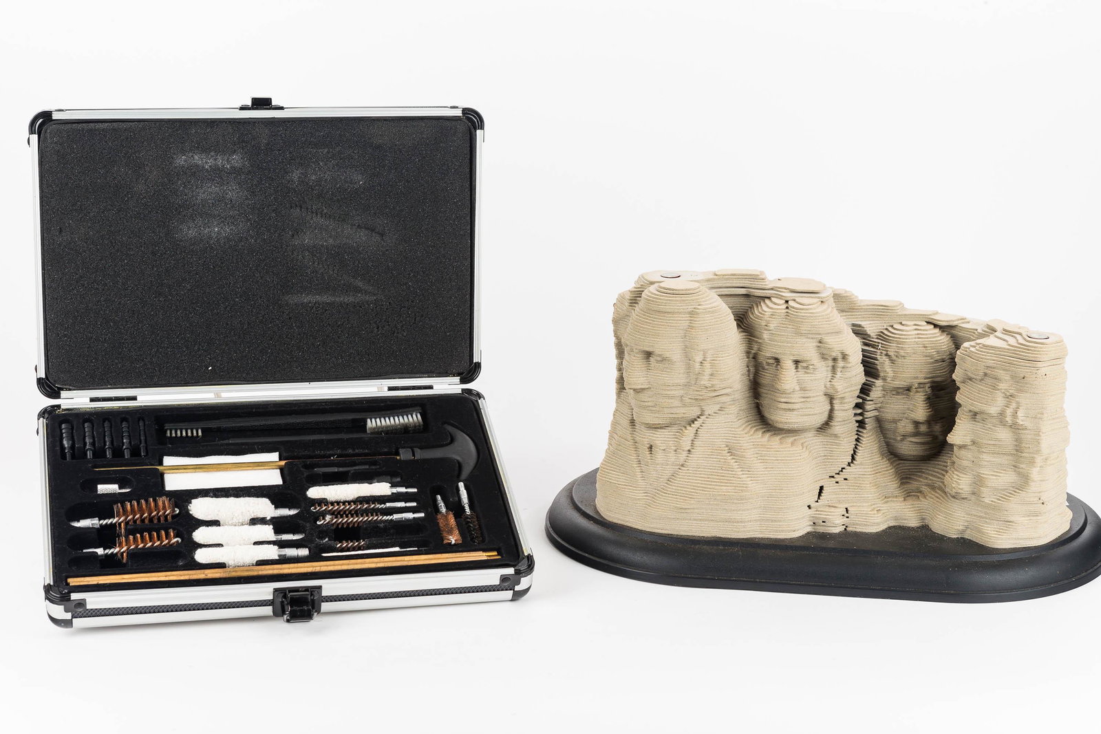 3-D Printed Mount Rushmore: This cardboard replica of Mount Rushmore measures approx. 7.5" H x 12" W not including base. It is made out of layers of cardboard. Lot also includes a gun cleaning kit.