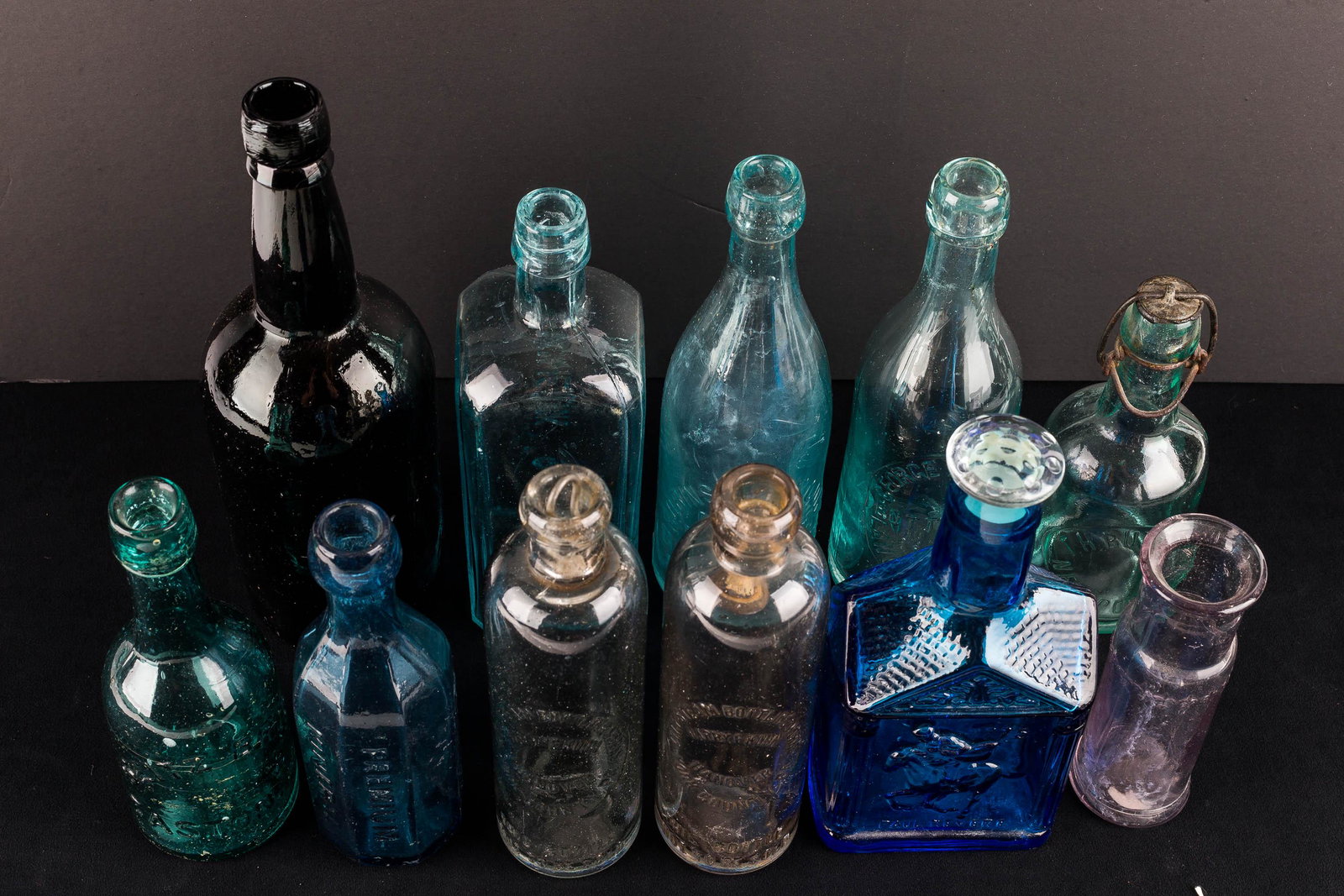 Vintage Advertising Beer & Tonic Bottles: a hand-blown brown wine bottle measuring approx. 10.5" H; a Shenk's Seaweed Tonic bottle; (2) City Steam Bottling Works; Hanover, PA bottles; a Robinson & Moore 13 fluid oz. bottle; a blue Premium min