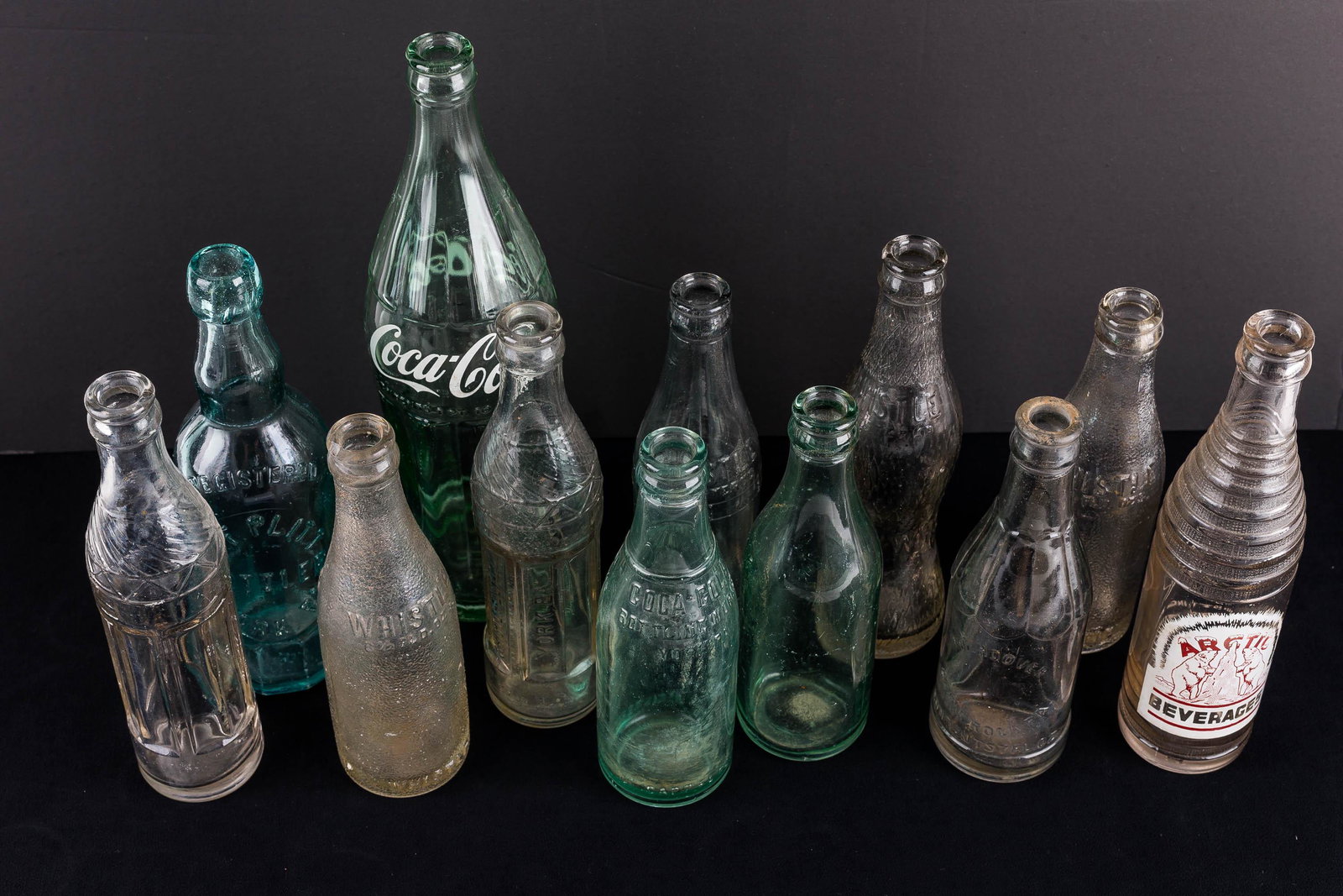 Vintage Soda Bottles: a Whistle Bottling Company, York, PA bottle; a frosted glass Whistle bottle; an early York, PA Coca-Cola bottle before the seams; C.F. Plitt, York, PA bottle; and others.