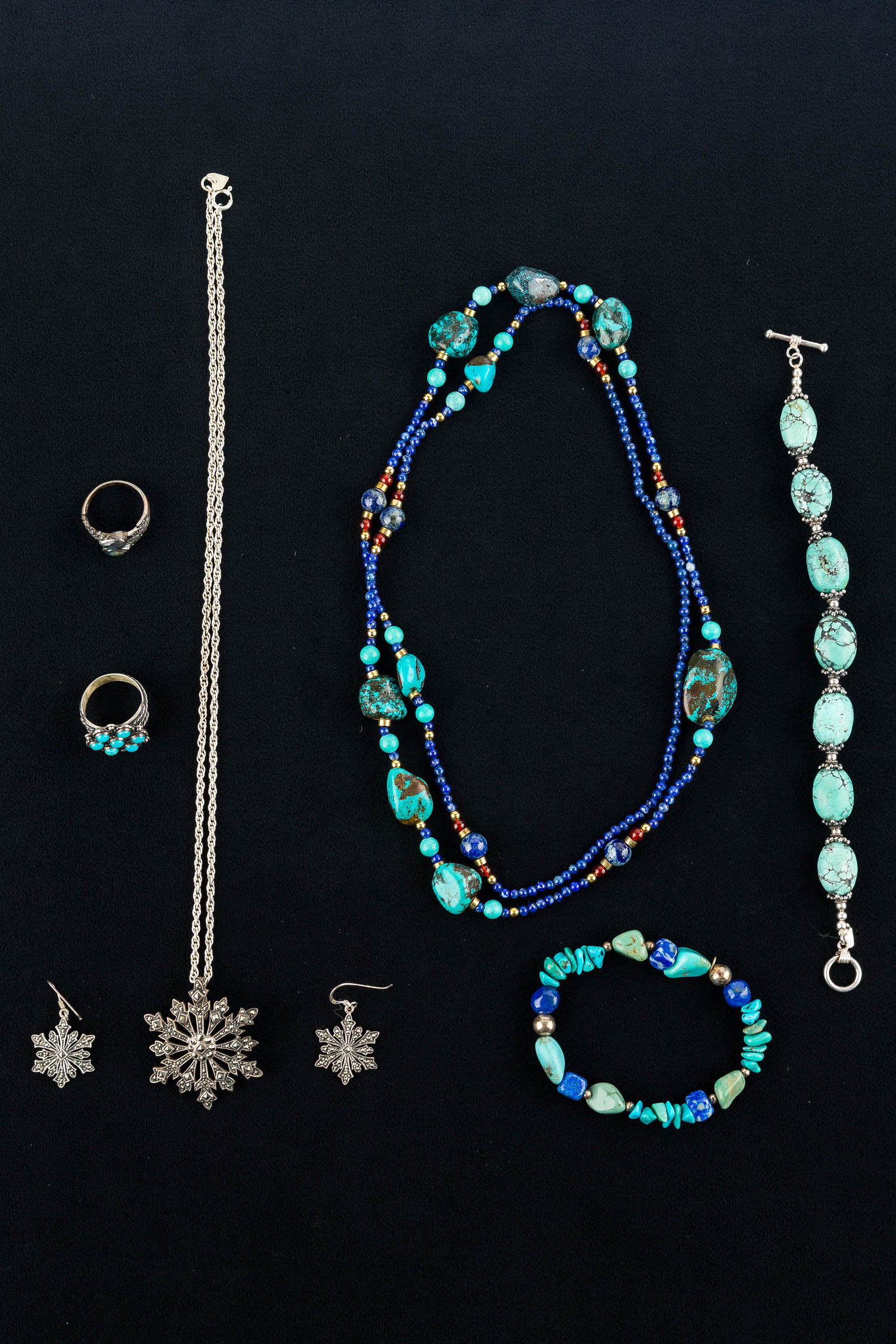 Turquoise & Sterling Silver Jewelry: a mottled turquoise and sterling beaded bracelet marked 925; a sterling snowflake pendant pin and earring set; a native sterling and turquoise ring marked '925 QT', size 8; a sterling and abalone ring