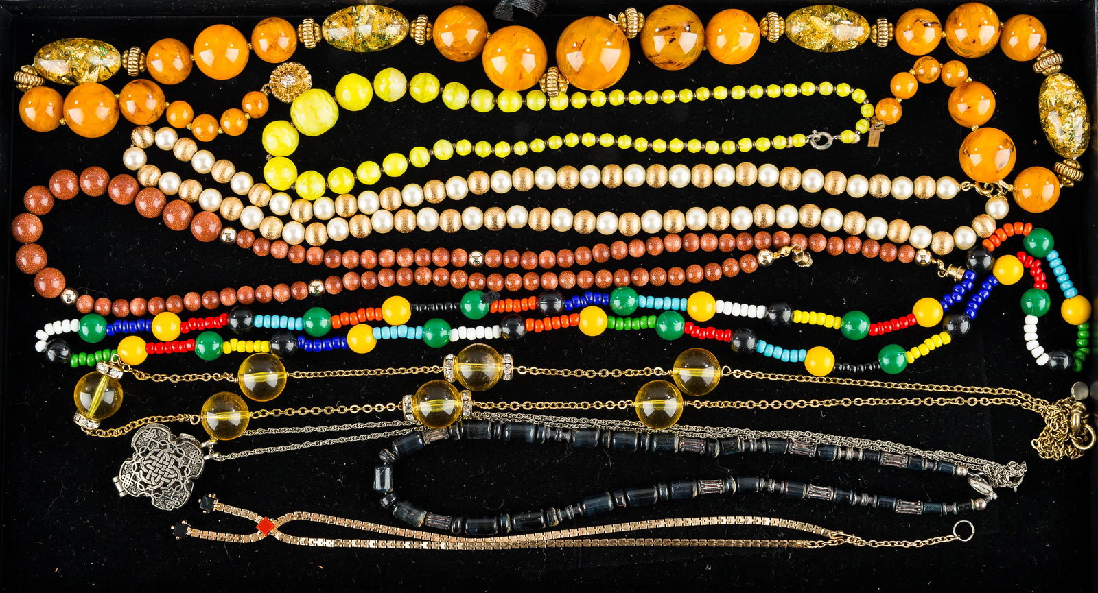 Beaded & Other Necklaces: a vintage butterscotch beaded necklace, a necklace with black mineral beads, a Camco Celtic style locket on chain, and related costume jewelry.