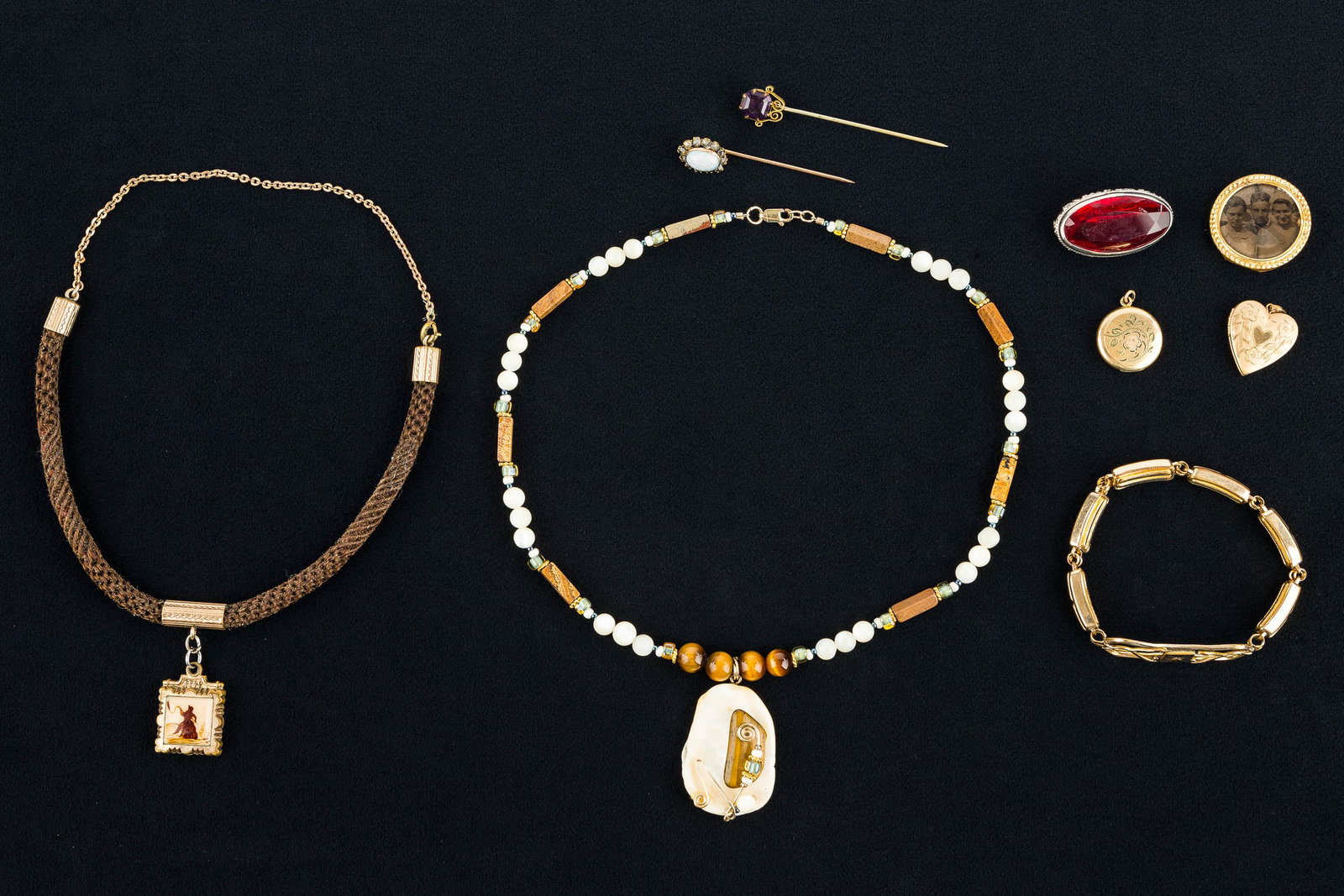 Gold Fill Jewelry Grouping: (2) gold fill lockets, a gold fill bracelet, a gold fill photo pin, (2) gold fill stick pins, and other gold fill jewelry.