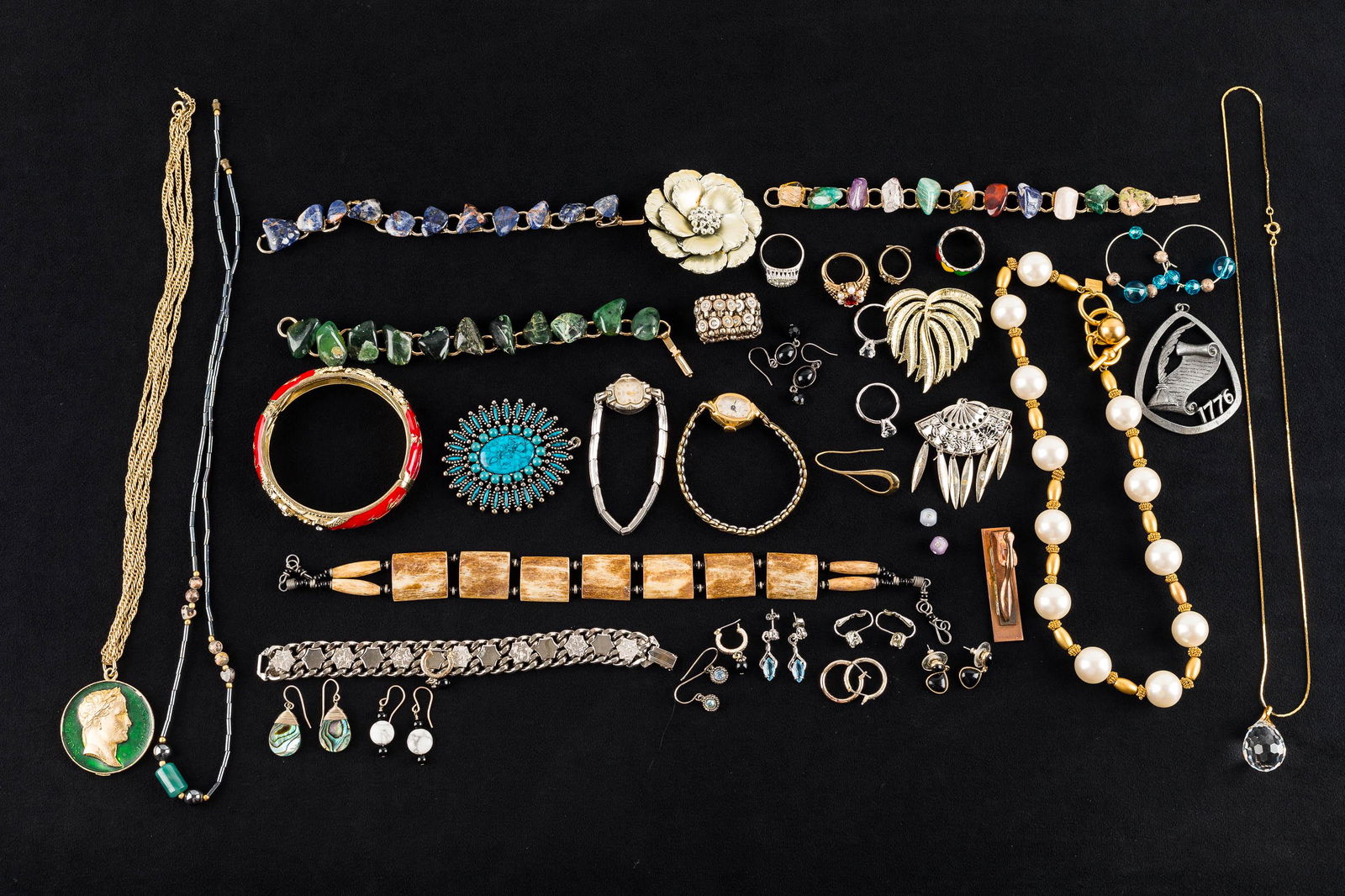 Mixed Costume Jewelry: a gold tone Anne Klein faux pearl necklace, a faceted crystal pendant on chain, a green polished mineral bracelet measuring approx. 7" L, floral and other brooches, and mixed mineral jewelry.