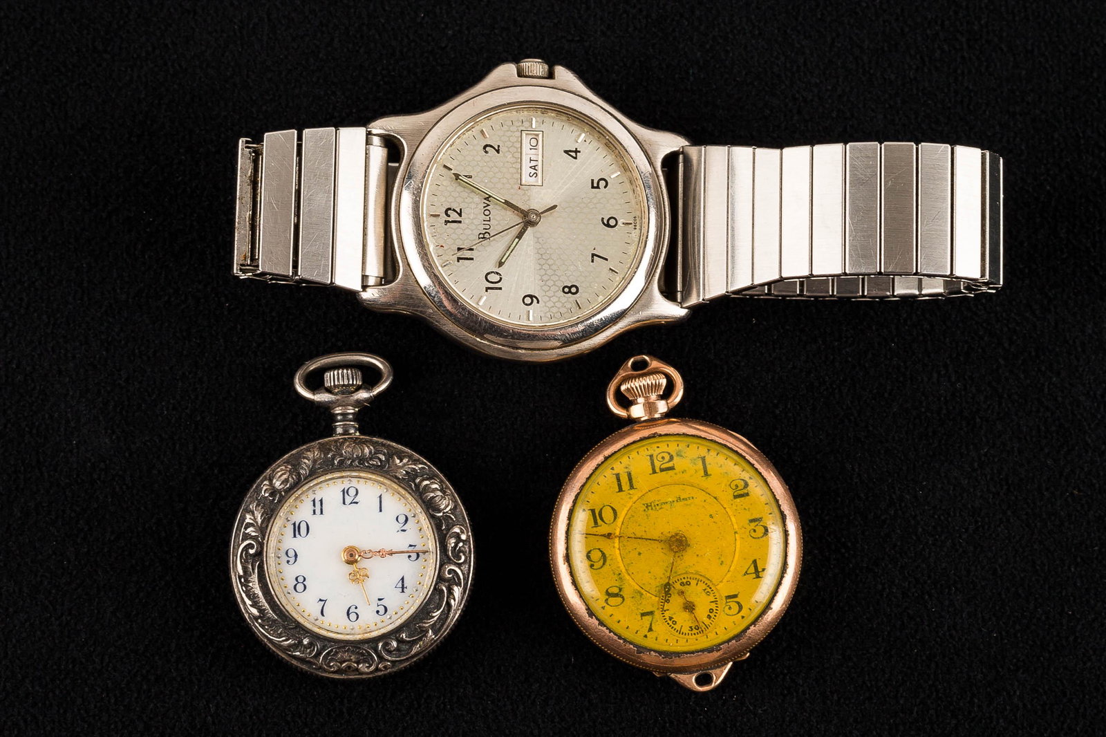 Victorian Repousse & Other Watches: a miniature Victorian repousse pocket watch with porcelain face and gold dot decoration, a Hampden pendant watch with gold fill case, and a men's Bulova stainless steel wristwatch with day & date mark