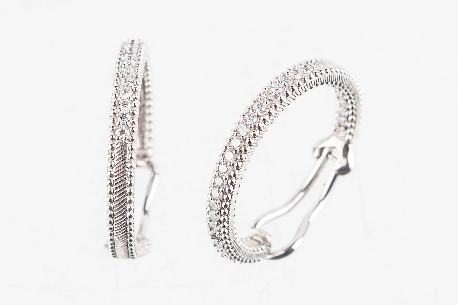 Judith Ripka Sterling Earrings: These sterling silver designer earrings are marked "Judith Ripka .925 Thailand" inside. Outside they features clear stone cubic zirconium in stylish hoops.