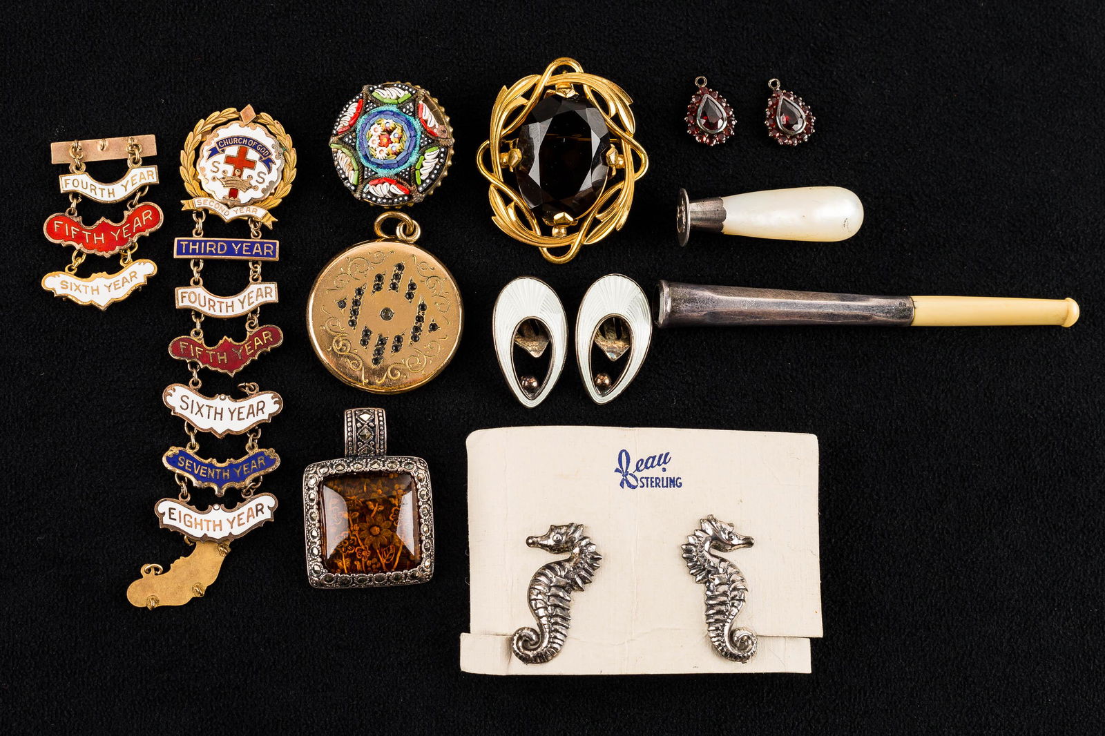 Sterling Silver Vintage Jewelry Collection: This collection features a pair of sterling silver clip earrings marked "DA" for David Andersen, seahorse screw back earrings marked "Beau", a carved silver cigarette holder, a mother of pearl silver