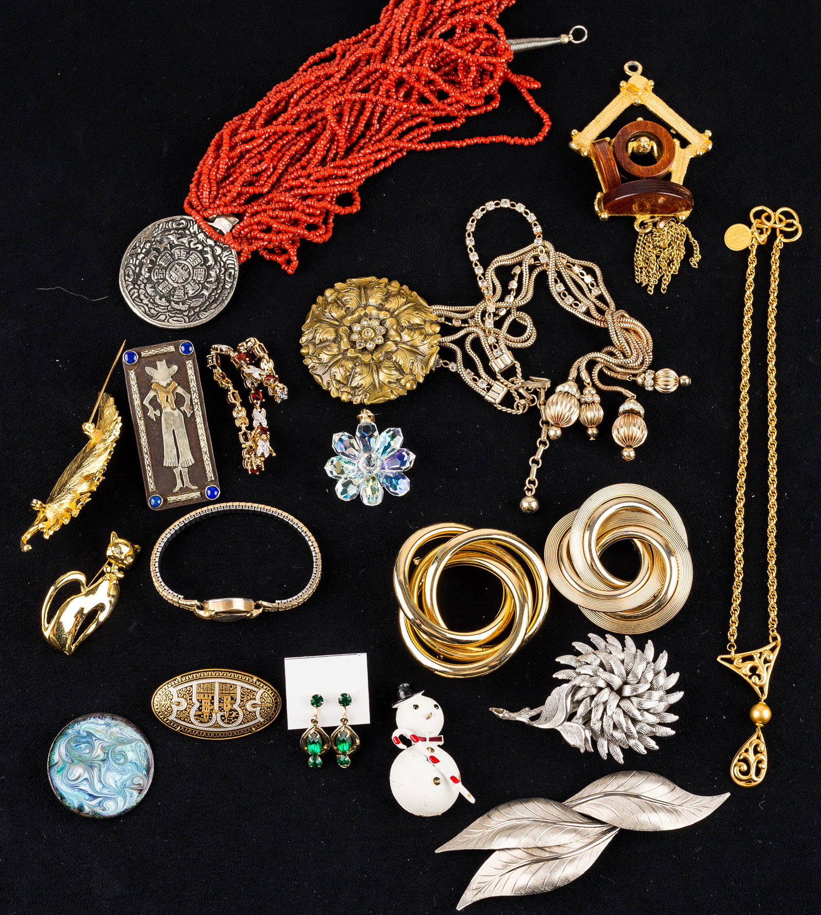 Large Brooches & Other Costume Jewelry: a multi-strand coral type necklace with Aztec pendant, gold tone necklace with teardrop pendant marked AK, various floral brooches, a southwestern brooch marked SA, a vintage ladies' Bulova wristwatch