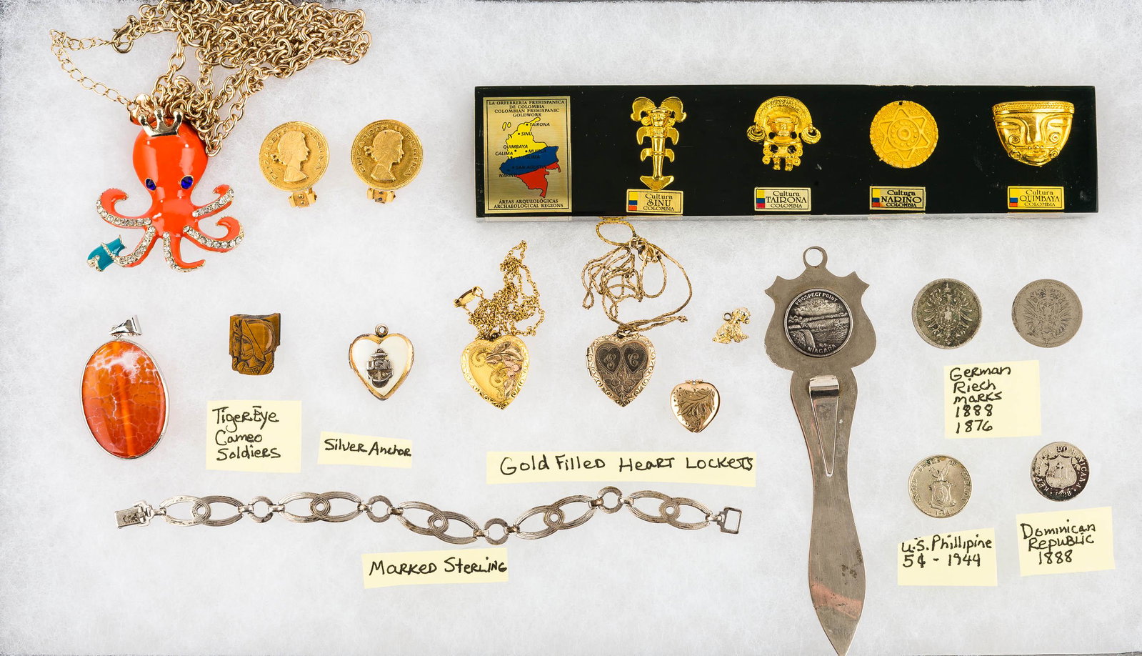 Sterling & Gold-Filled Jewelry: This collection features (3) gold-filled heart lockets, a sterling silver chain link bracelet, a carved tiger eye of a warrior, a heart locket with silver anchor marked "USN", and vintage coins.