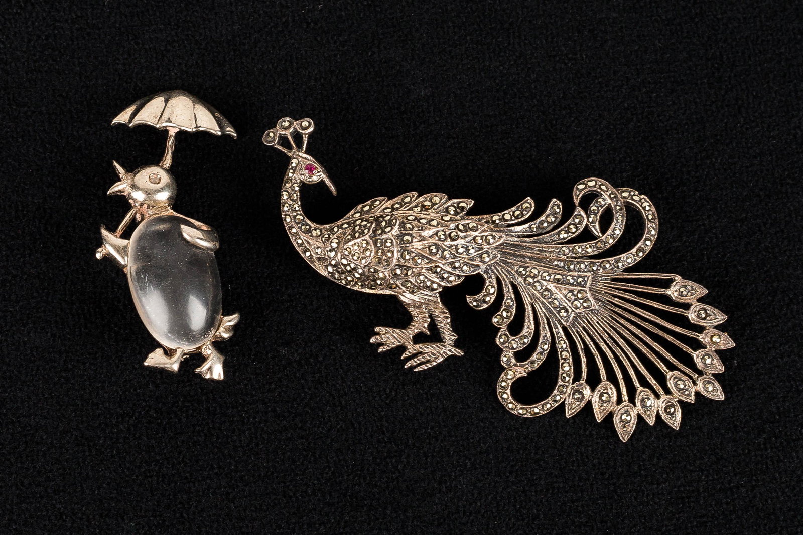 Sterling Jelly Belly Penguin & Peacock: This lot features a penguin pin with a clear Jelly Belly measuring approx. 2" H, and a marcasite inlay sterling silver peacock brooch.