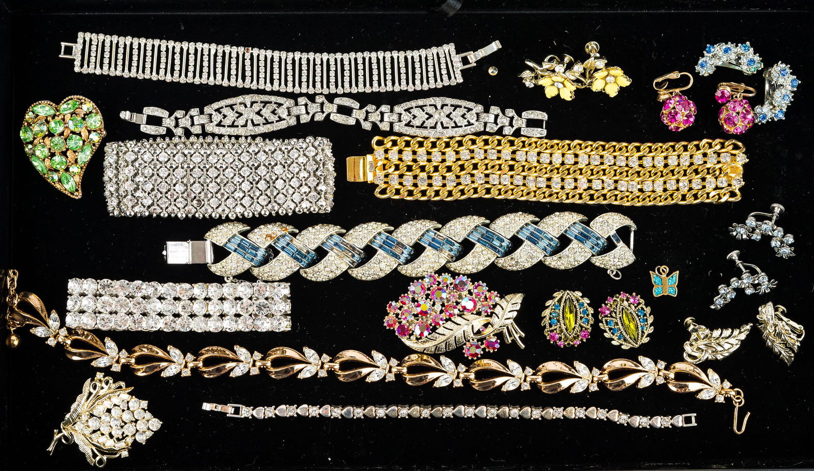 Quality Rhinestone Jewelry Collection: This collection features a delicate rhinestone and silver tone heart bracelet marked "BMNY", a heart-shaped brooch with green rhinestones, various rhinestone bracelets, a leaf brooch with pink rhinest