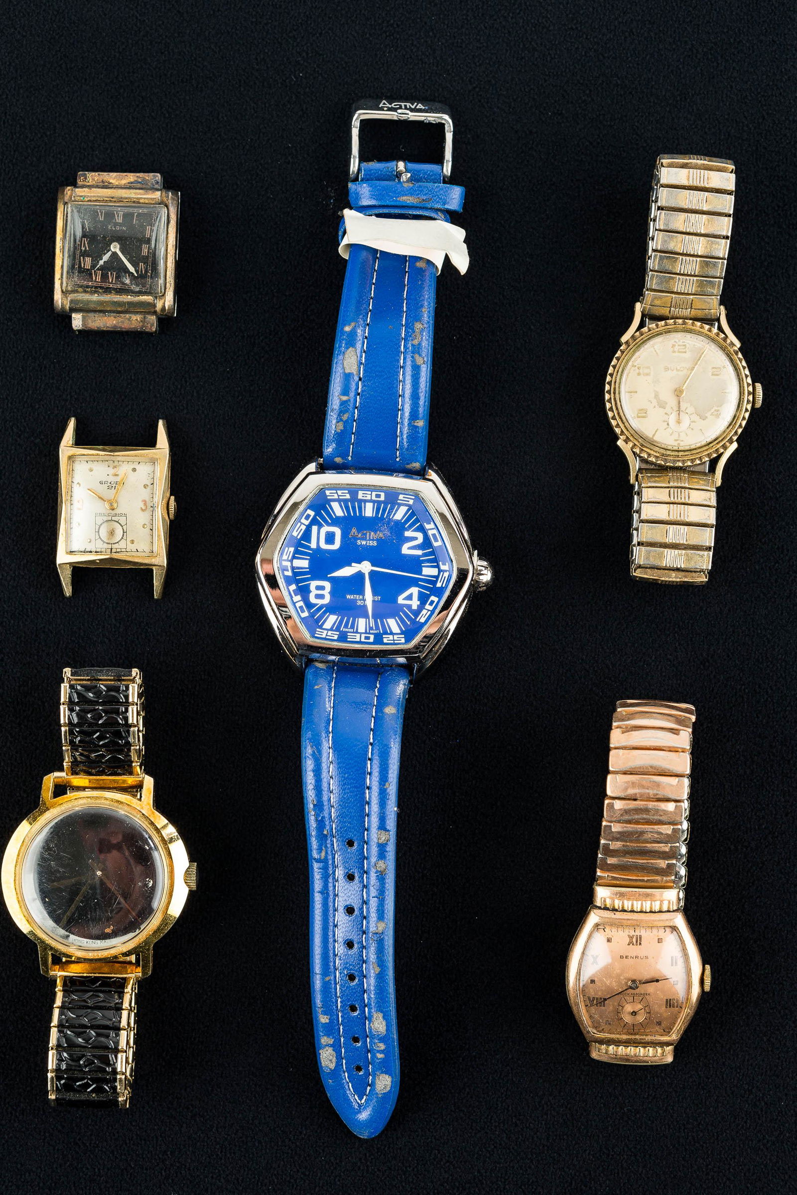 Men's Watch Grouping: This grouping includes a blue Activa Swiss watch (with wear to band), vintage gold tone Bulova (showing wear), an art deco Benrus, a Gruen without a band, and others/