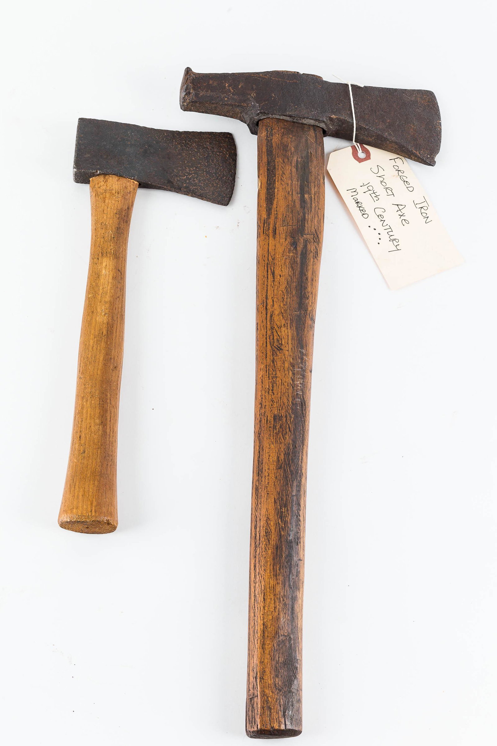 Hand-Forged Short Axes (2): The hand-forged iron short axe with obscure maker's mark on blade has a hardwood handle which appears to be an early replacement. The blade measures approx. 2.75"H and has an old chip. It has a hammer