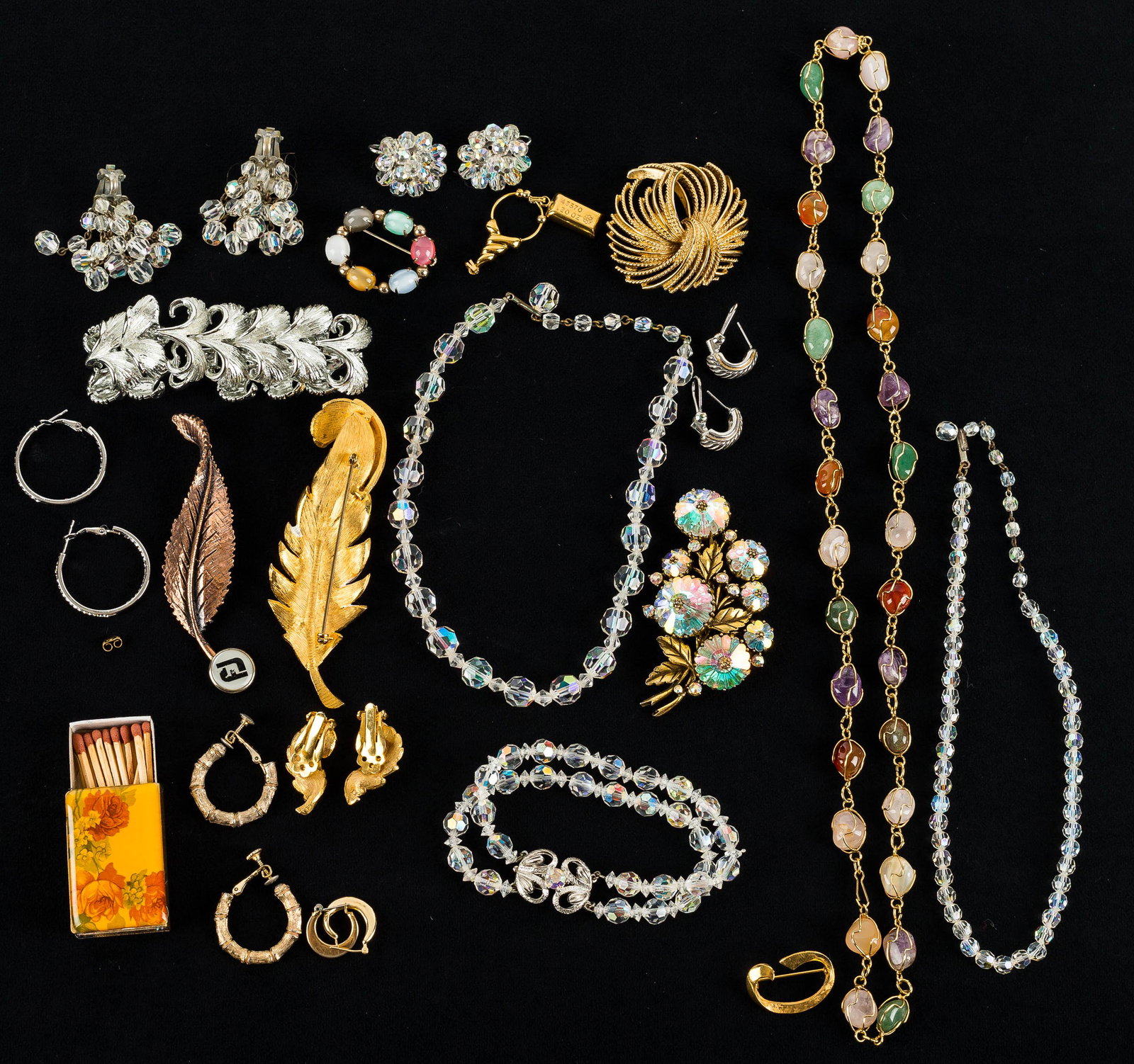 Weiss, Lisner, & Other Costume Jewelry: This collection features a vintage Weiss faceted crystal floral brooch measuring approx. 3", a gold tone Monet fireworks brooch, a silver tone Lisner leaf bracelet, a polished mineral necklace, a Mone