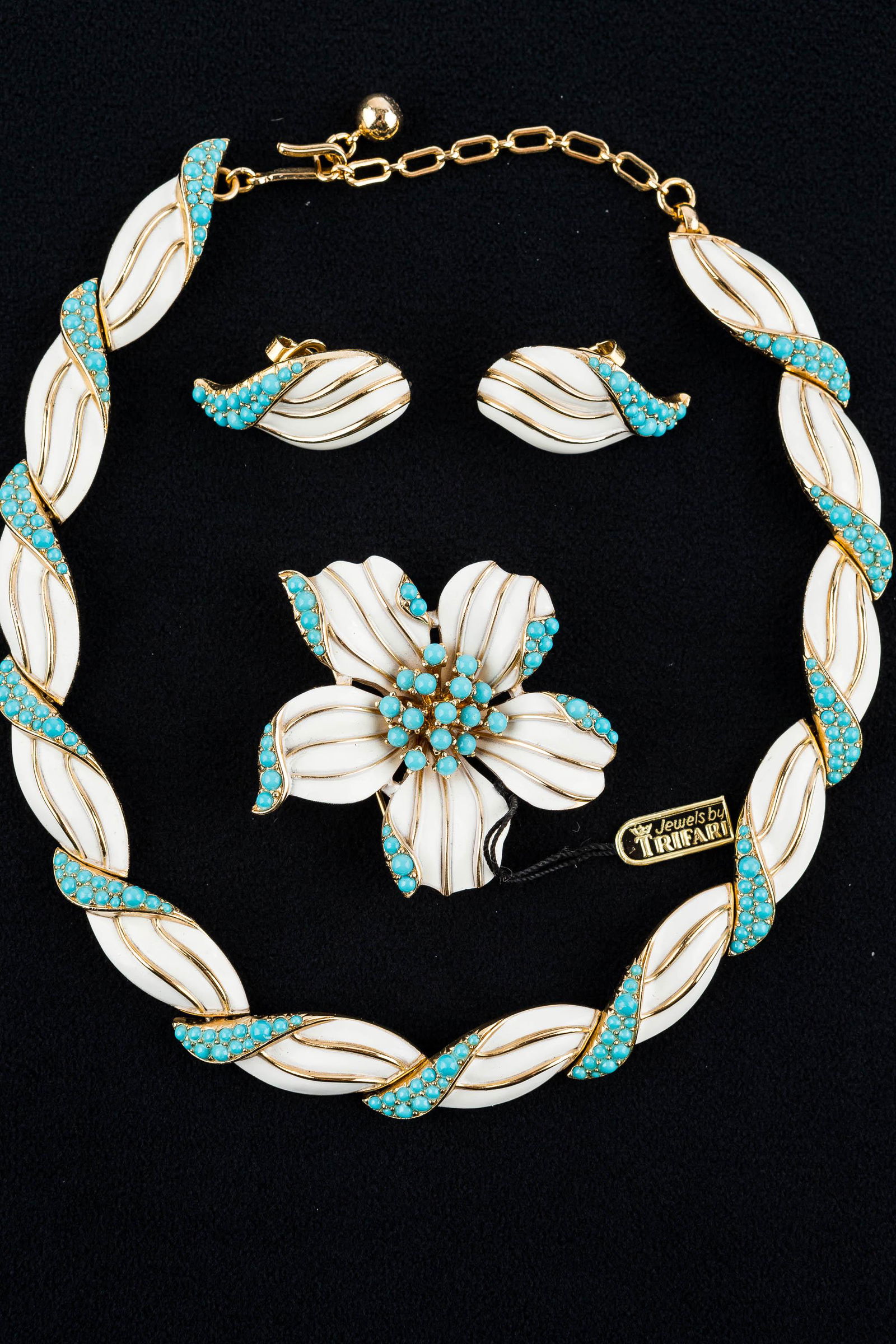 Trifari Vintage Estate Jewelry Suite: This signed Trifari set of a white enameled floral brooch, necklace and earrings with turquoise style detail is signed with Trifari crown-over-T mark and retains the original hang tag reading "Trifari