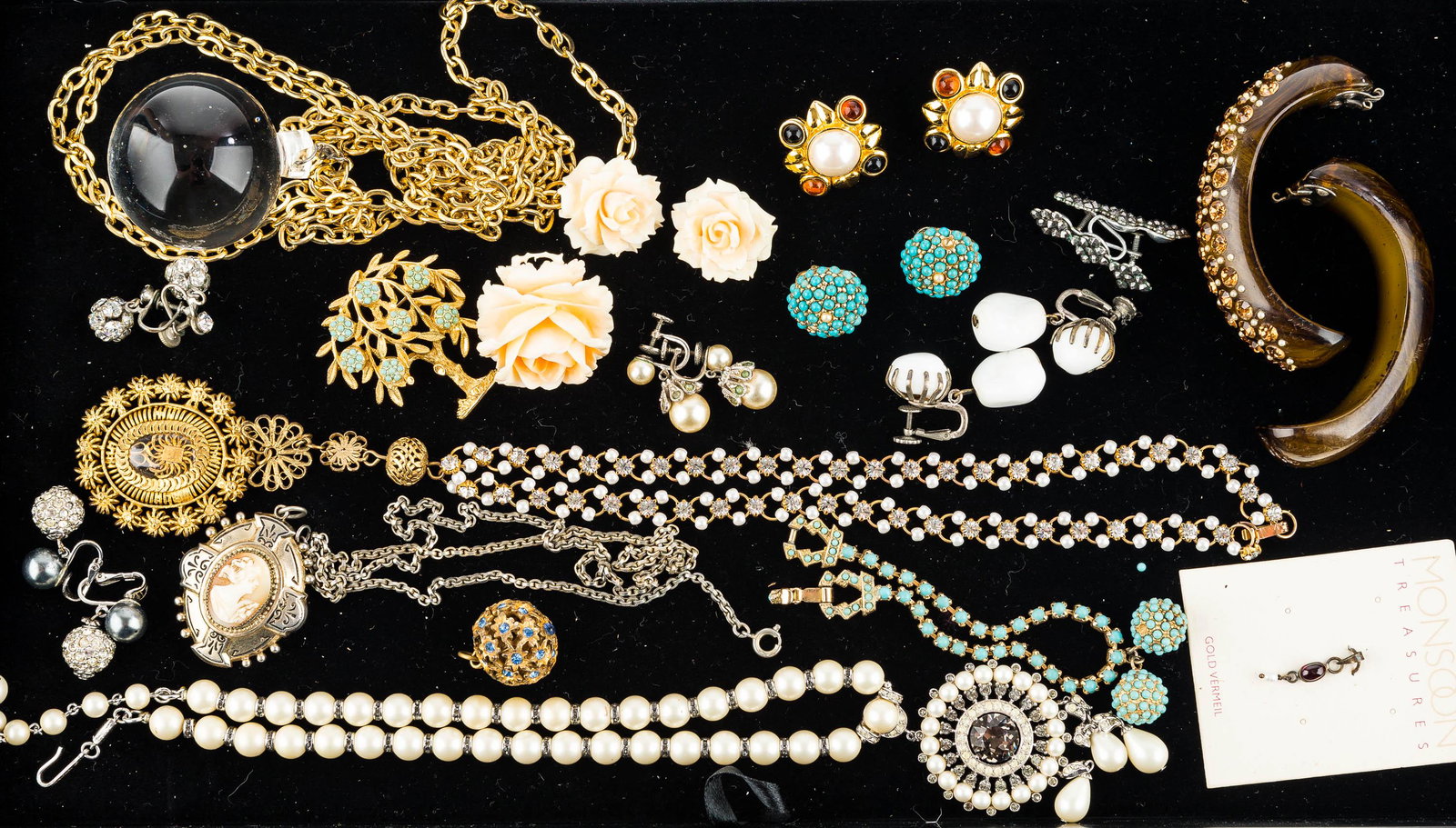 Vintage Signed Estate Jewelry: This collection features a Trifari pearl and rhinestone necklace signed with crown measuring approx. 17.5"L, a cameo locket on chain measuring approx. 21.5"L, a gold tone fruit tree pin marked "KJL", 