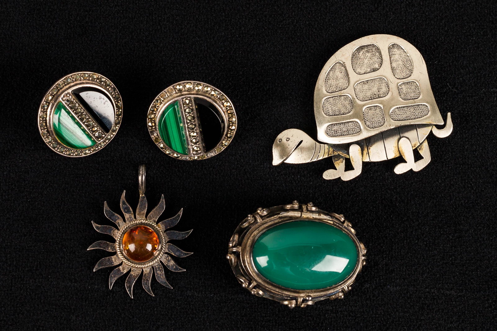 Beau & Mexican Sterling Silver Jewelry Collection: This collection features a cartoon-esque turtle brooch marked "Beau Sterling" measuring approx. 2", a large Mexican sterling locket brooch with deep green stone, an amber sterling sun pendant, and mar