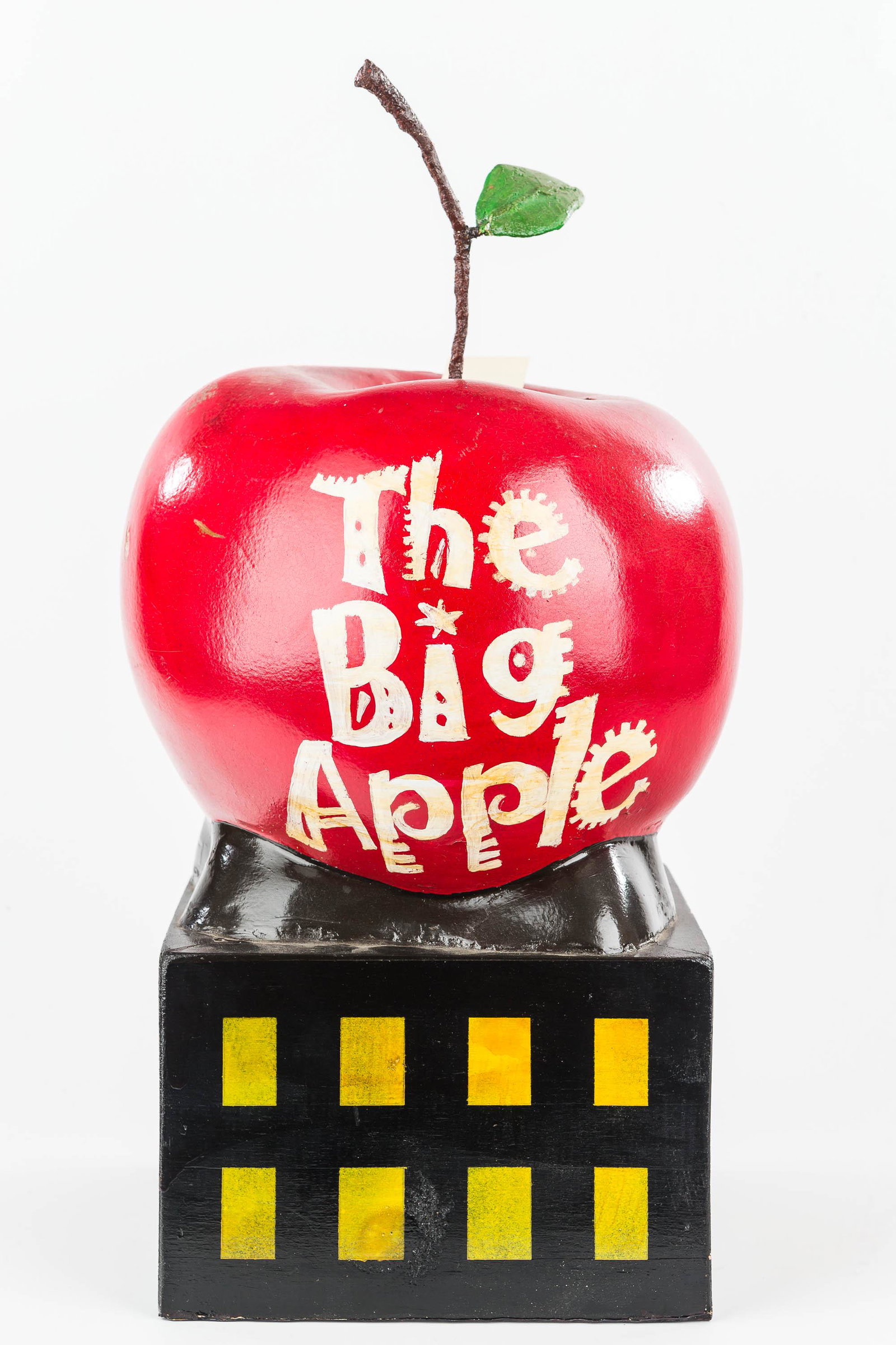 Composition Big Apple: This decorative apple sits on top of a building. The apple is composition and the base is wooden. Measures approx 19" to top of stem.