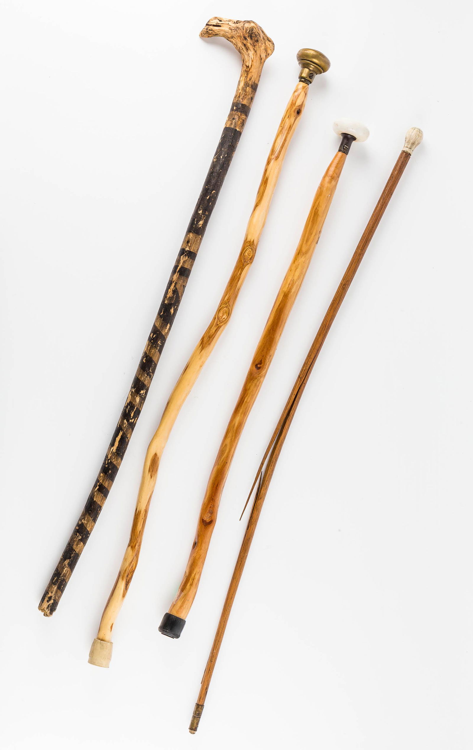 Wood Canes (4): Two canes have door knob handles. Another is a folk art painted cane marked RTB. The 4th has a bone handle and shaft has a split / broken. The longest one measures approx 36".
