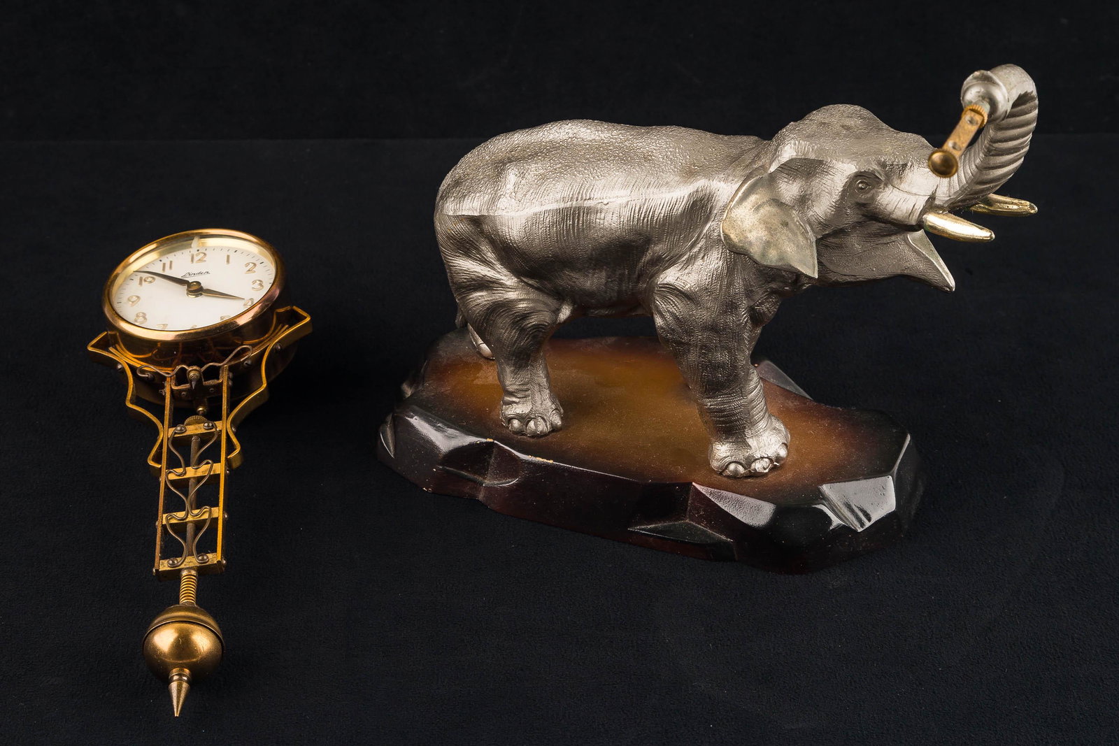 Linder Elephant Swinging Clock: This clock swings on a rod at the end of the elephant trunk and is marked Japan. The base looks like composite material so estimated to be mid 20th C. The original 1900 model of the elephant swinging 