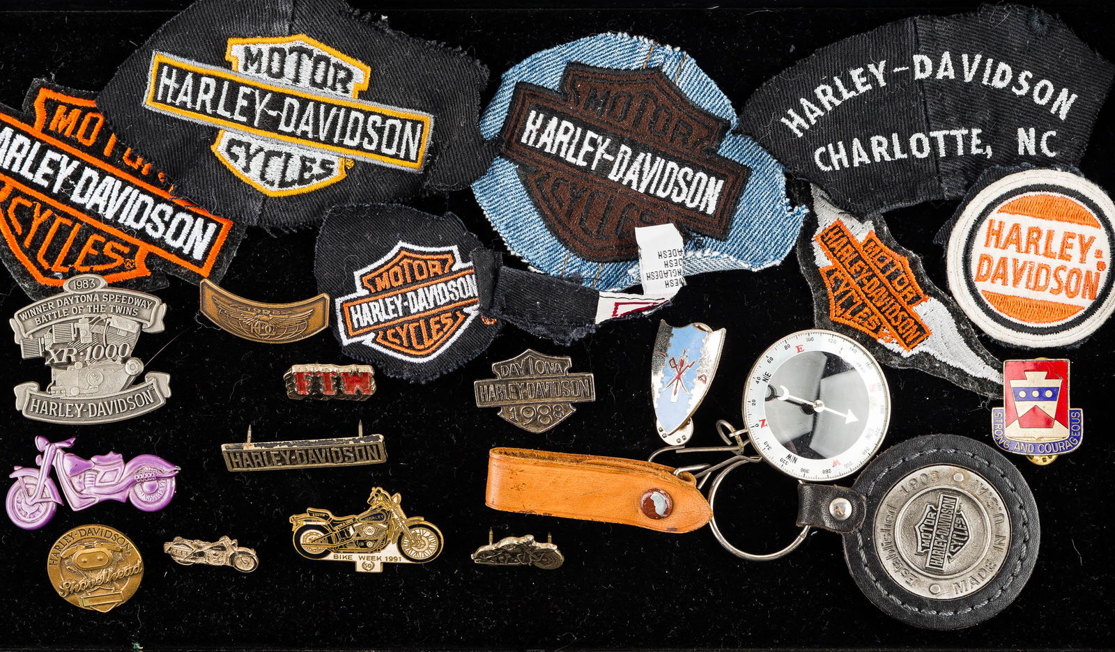 Harley Davidson Patches & Related: Lot includes (7) cloth Harley Davidson patches, a selection of Harley lapel pins, and a 1999 Harley Davidson keychain.
