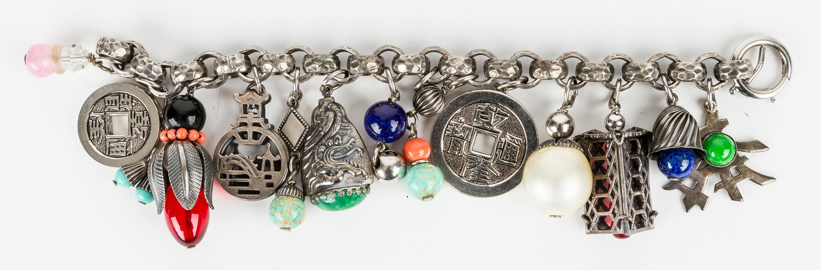 Asian Style Designer Charm Bracelet: This charm bracelet has 12 Asian style charms. It is made with mixed metals and includes turquoise, jade and silver color accents. Napier is marked on clasp. It measures approx 8" L, heavy with large