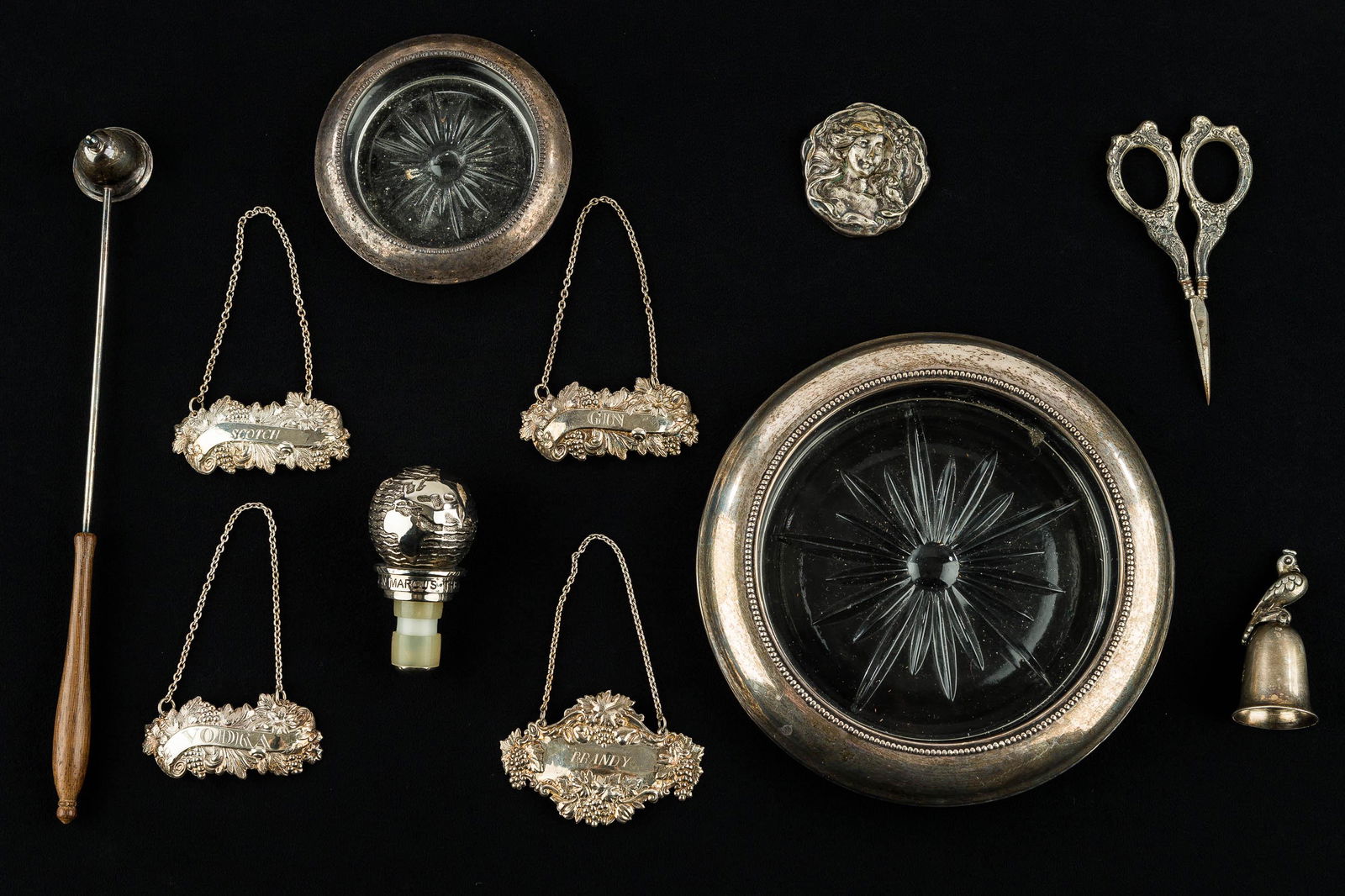 Sterling Silver Sewing & Table Accessories: Sterling wine coaster, coaster, sterling liquor labels, sterling snuffer, sterling sewing bird scissors, non-sterling/unmarked items include a Neiman Marcus 'The New Millennium' bottle stopper, Victor