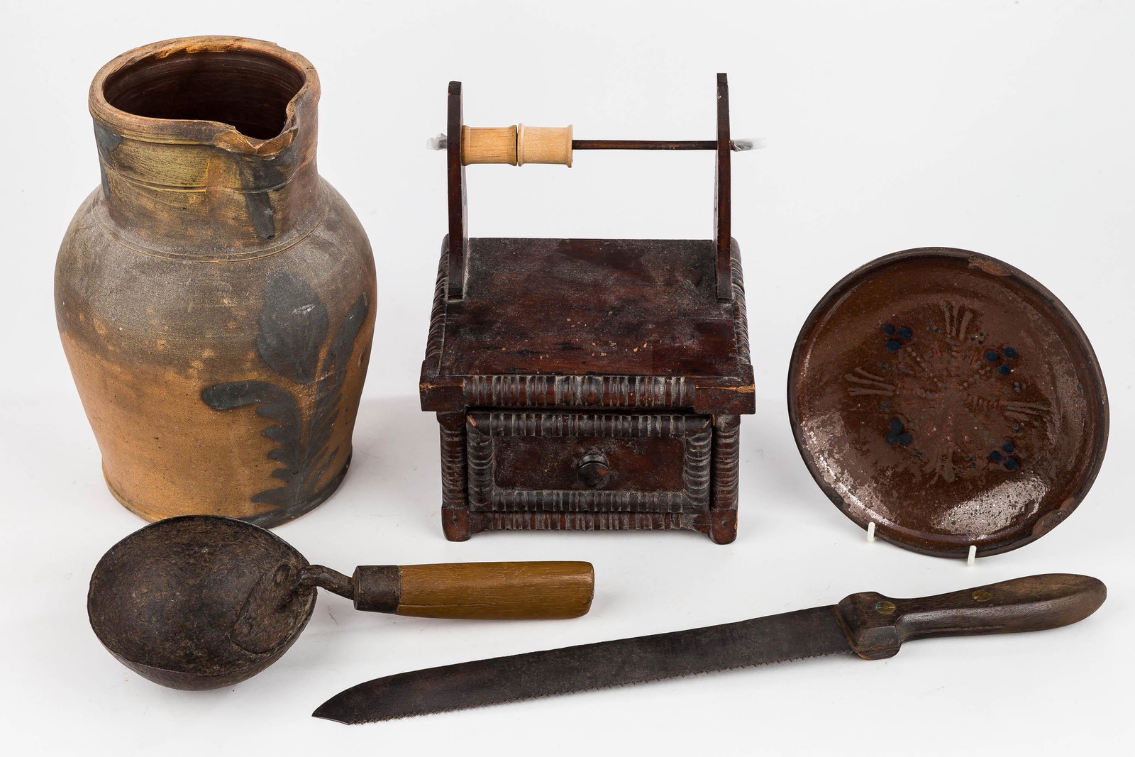 19th C. Pottery, Sewing & Kitchen Primitives: 19th C. sewing box with signature on back of drawer (knobs on spool rod missing), primitive ladle, redware slip decorated plate approx 7.5" diam, signed but illegible bone saw, and blue decorated ston