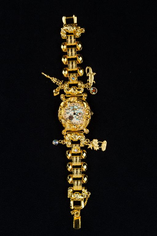 "Kirks Folly" Ocean Inspired Watch: Signed "Kirks Folly" gold tone charm watch with mermaid bezel and sea related charms.