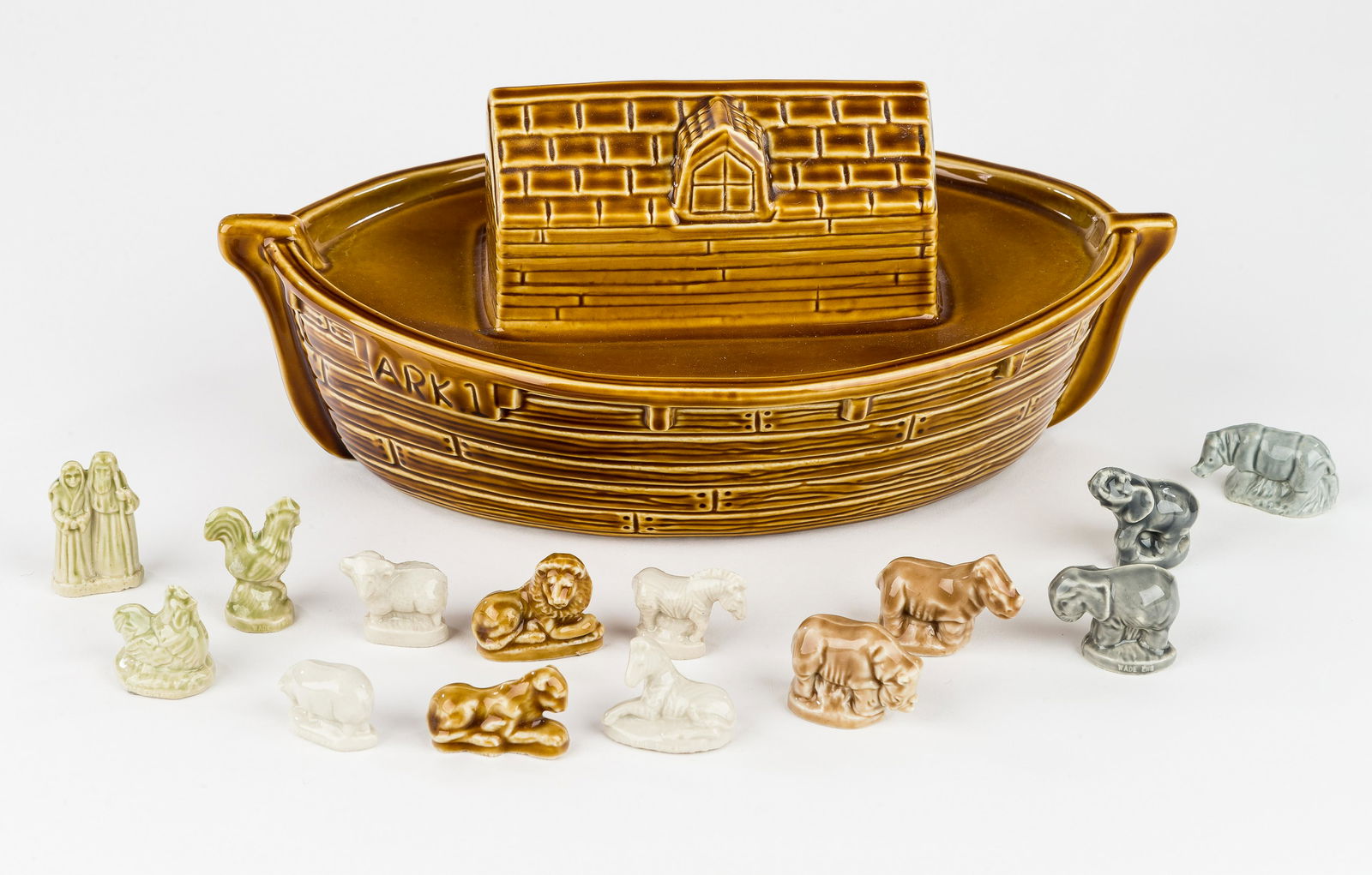 Wade Noah's Ark Figurine & Animals: There is a Wade pottery figurine of Noah's ark. Marked "Wade" on the bottom. There are 12 small animals and a figure of Noah & wife. Measures approx 11" L. Good condition.