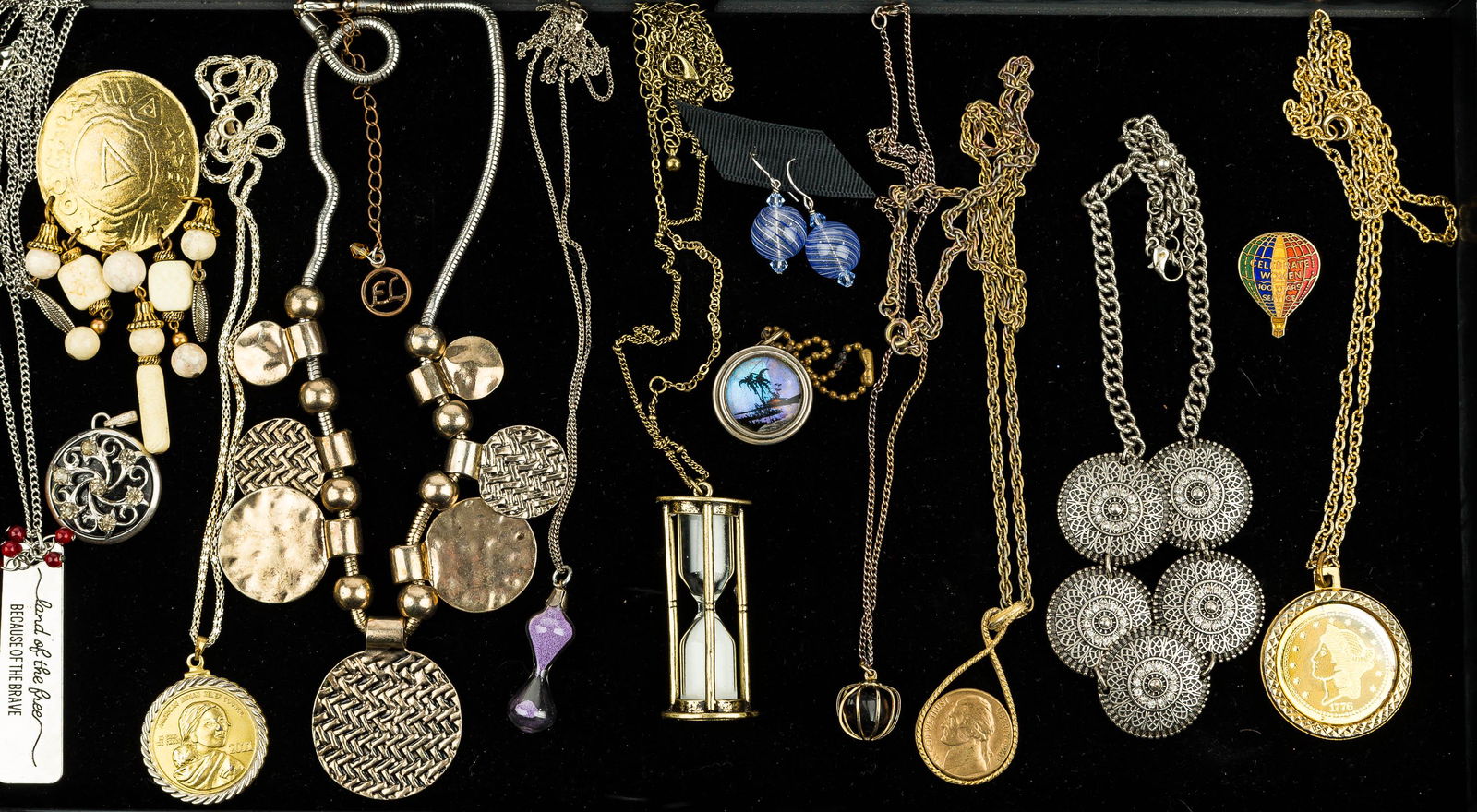 Costume Jewelry Grouping: Costume Jewelry. This Jewelry includes 14 items featuring two hourglass necklaces, a pair of blown glass swirl sphere earrings, a spring loading coin keychain, and other items.