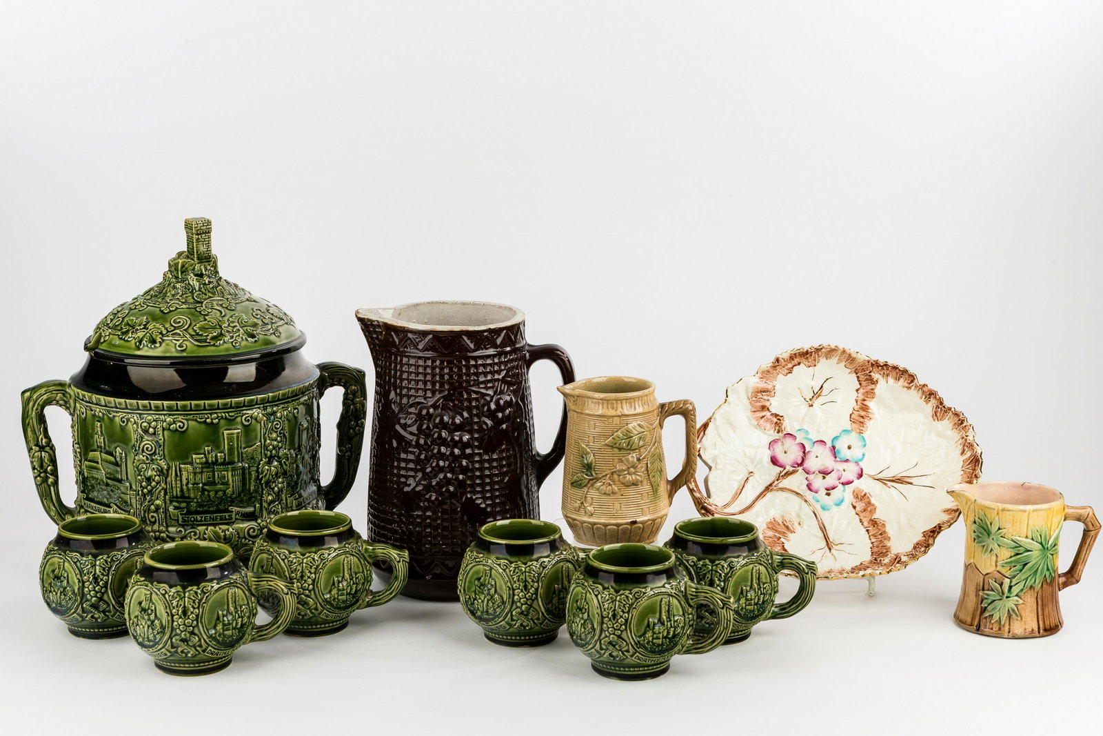 Castle Punch Bowl Set & English Pottery: Marzi & Remy green majolica castle punch bowl and six matching mugs, bowl approx 12"H x 8.5" diam (excluding handles) features castle finial, has small flea bite rim chip, mugs are in good condition, 