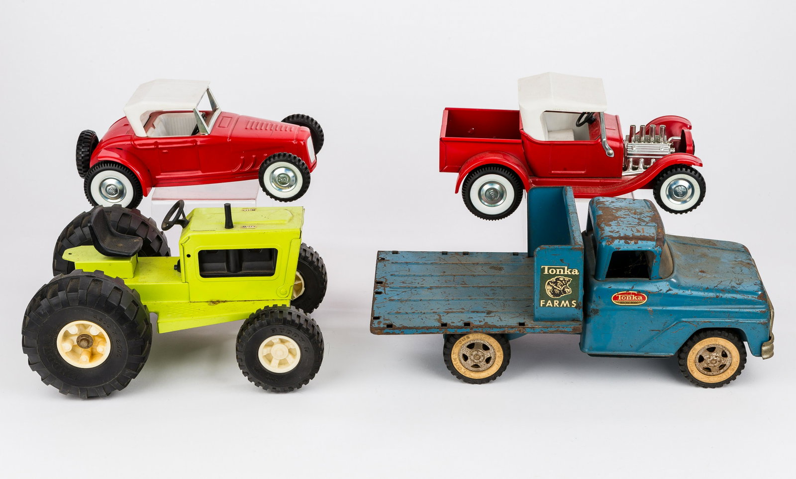 Tonka Truck, Buddy L Tractor & Nylint Cars: Dark blue Tonka 'Tonka Farms' flat bed pick up truck (no fencing) with paint loss, oxidation throughout, intact windshield and head lights, decals on both sides, rolls easily approx 13.75"L, Buddy L l