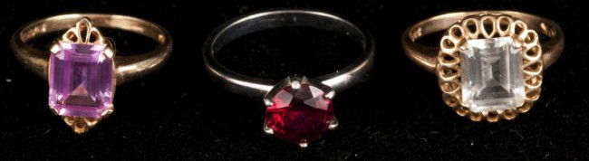 10k Gold Ring Lot: Three gold rings. 10K white gold with a synthetic ruby, a 10K yellow gold with a syn. Ruby, and a 10K yellow gold with a colorless spinel, ring sizes 6, 5, & 5, 4.0dwt.